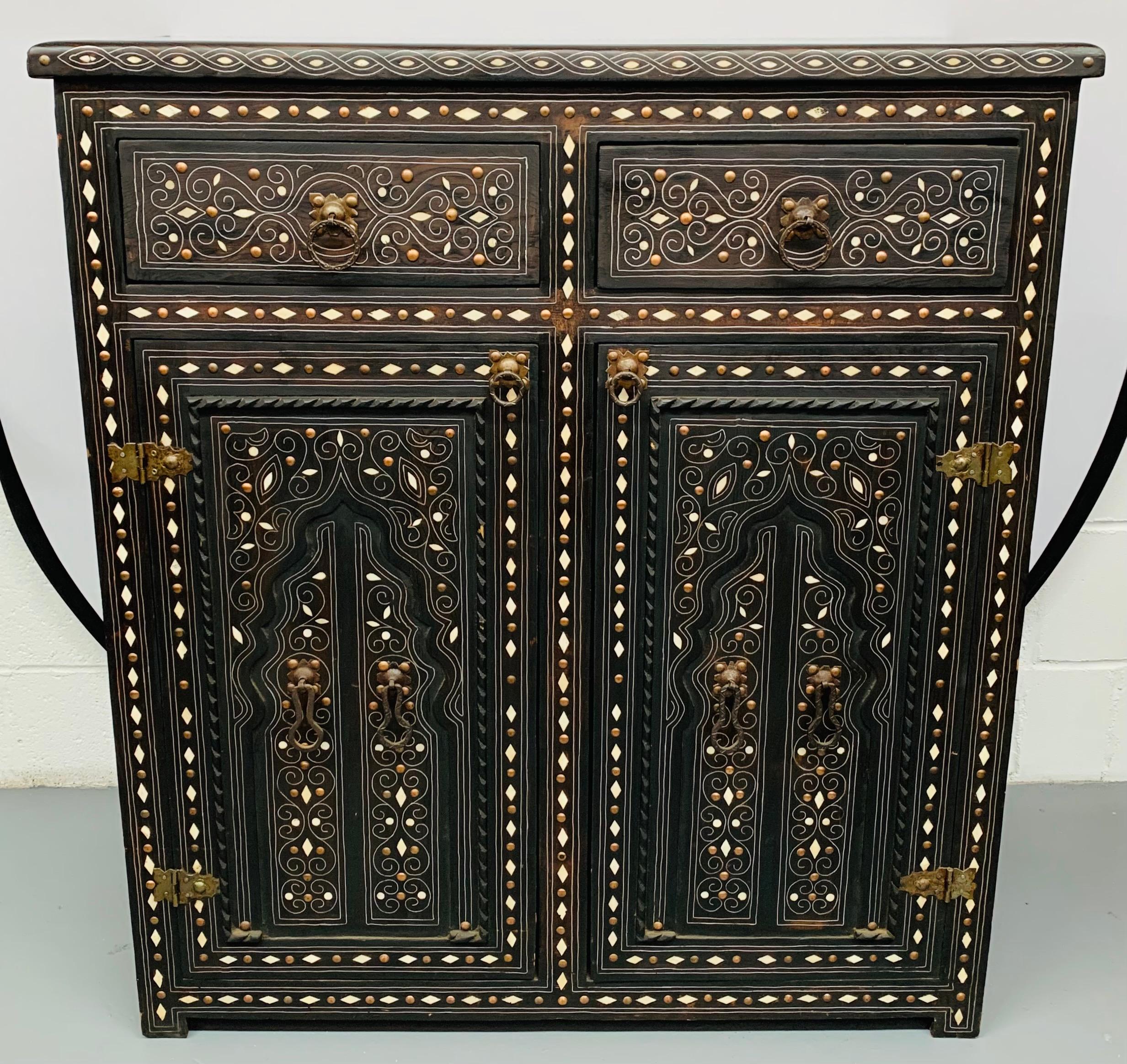 An early 20th century unique piece that was acquired in a Riad of a private collector in Marrakech. The chest, commode to cabinet features high quality inlay of white camel bone and brass. The ebonized wood will make this piece seamlessly blend in