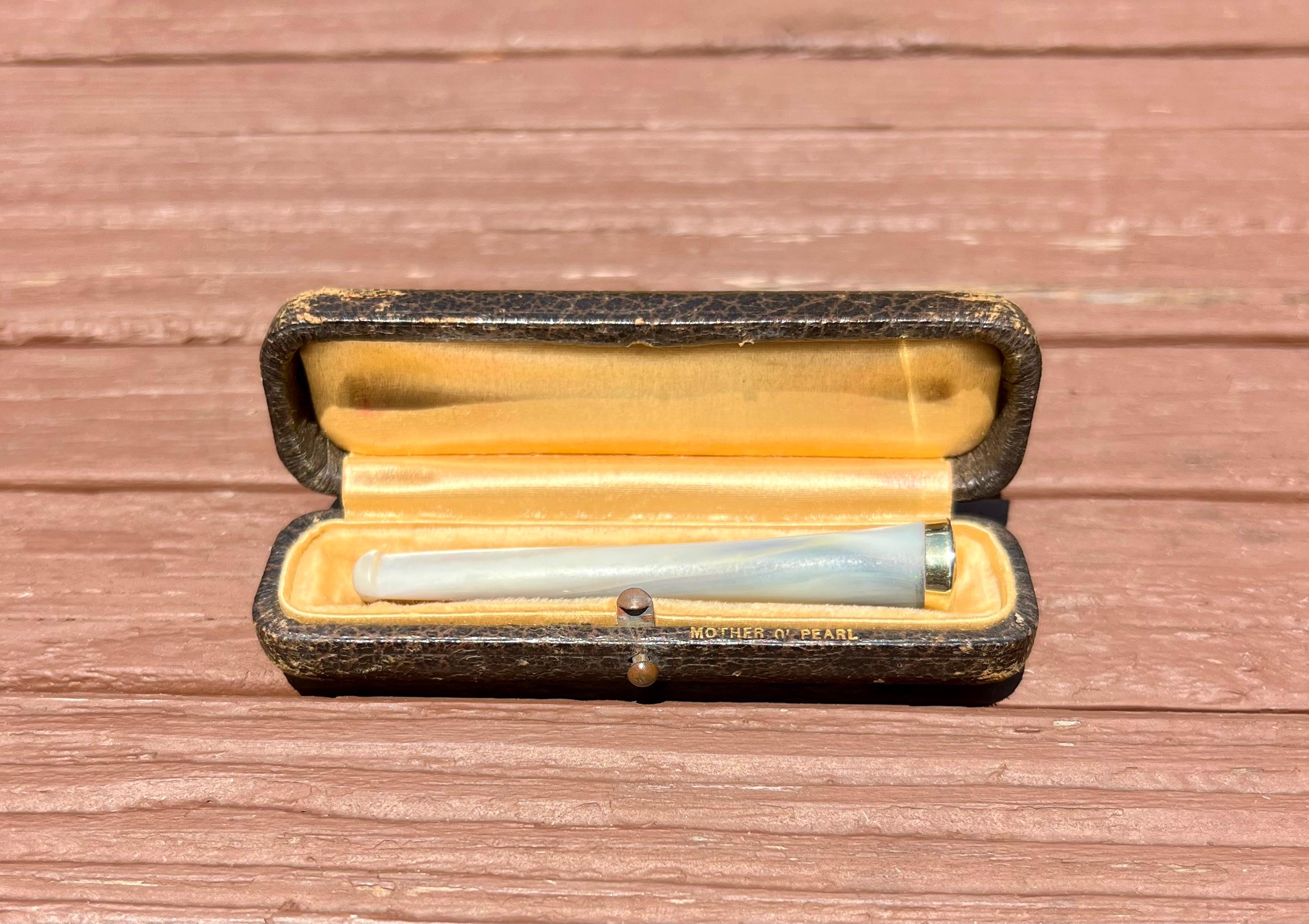 One 14 karat yellow gold (stamped 14K) and mother of pearl cigarette holder with case.  The cigarette holder measures three (3) inches long and is circa 1920s.  