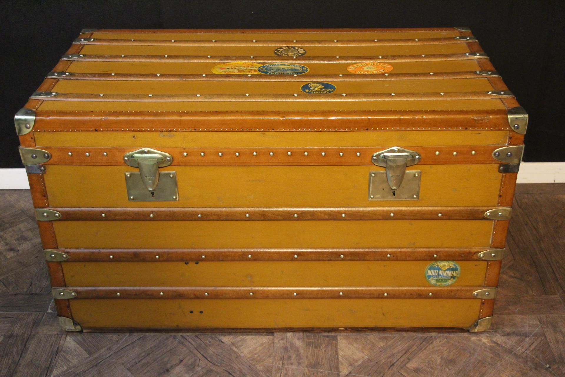 This Moynat steamer trunk features a very nice golden brown orange canvas as well as brass corners, solid brass Moynat stamped locks, honey color trims and large leather side handles. There are still a couple of travel labels and customized painted