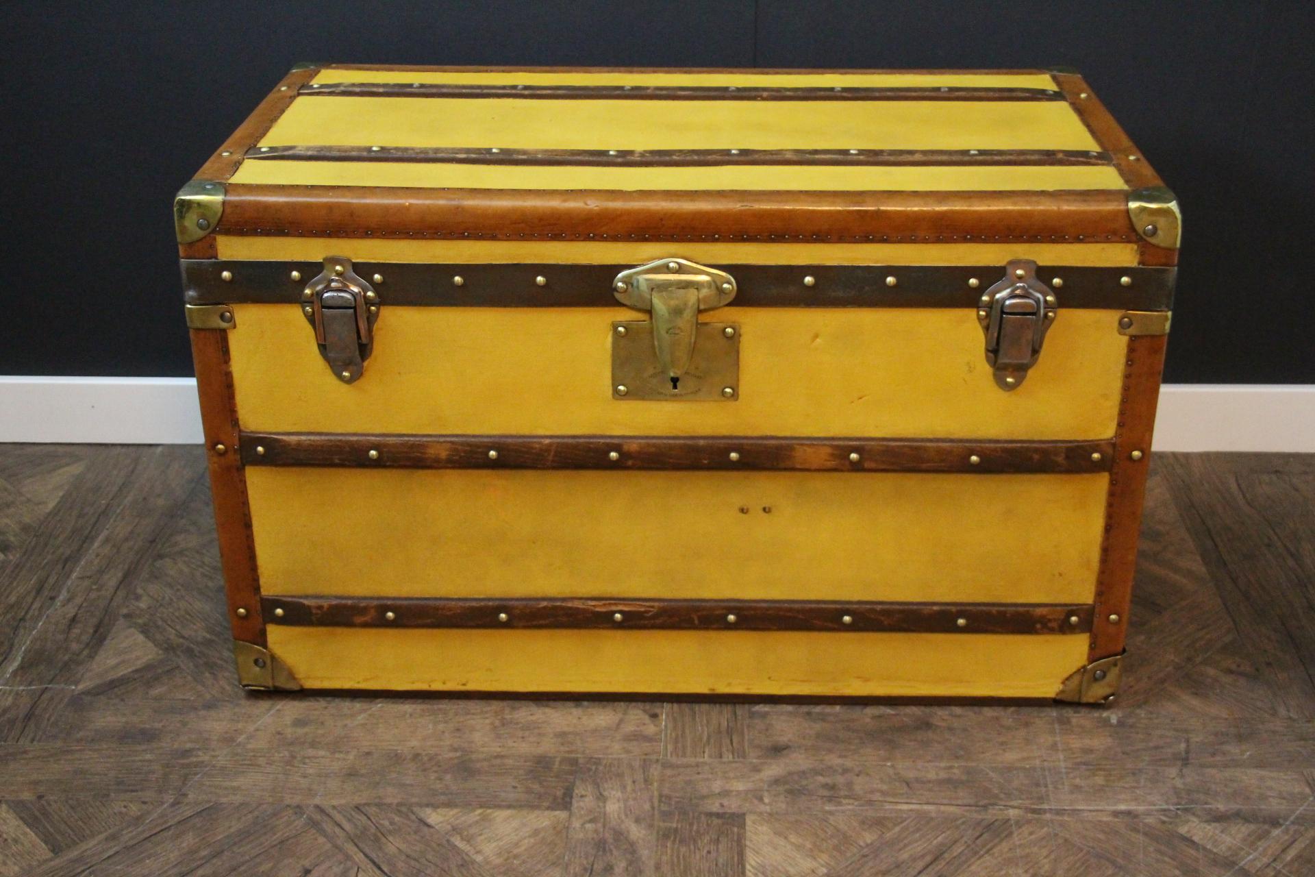 This Moynat steamer trunk features a very nice yellow canvas as well as brass corners, solid brass Moynat stamped lock, honey color trims and large leather side handles. Its handle latches are marked 