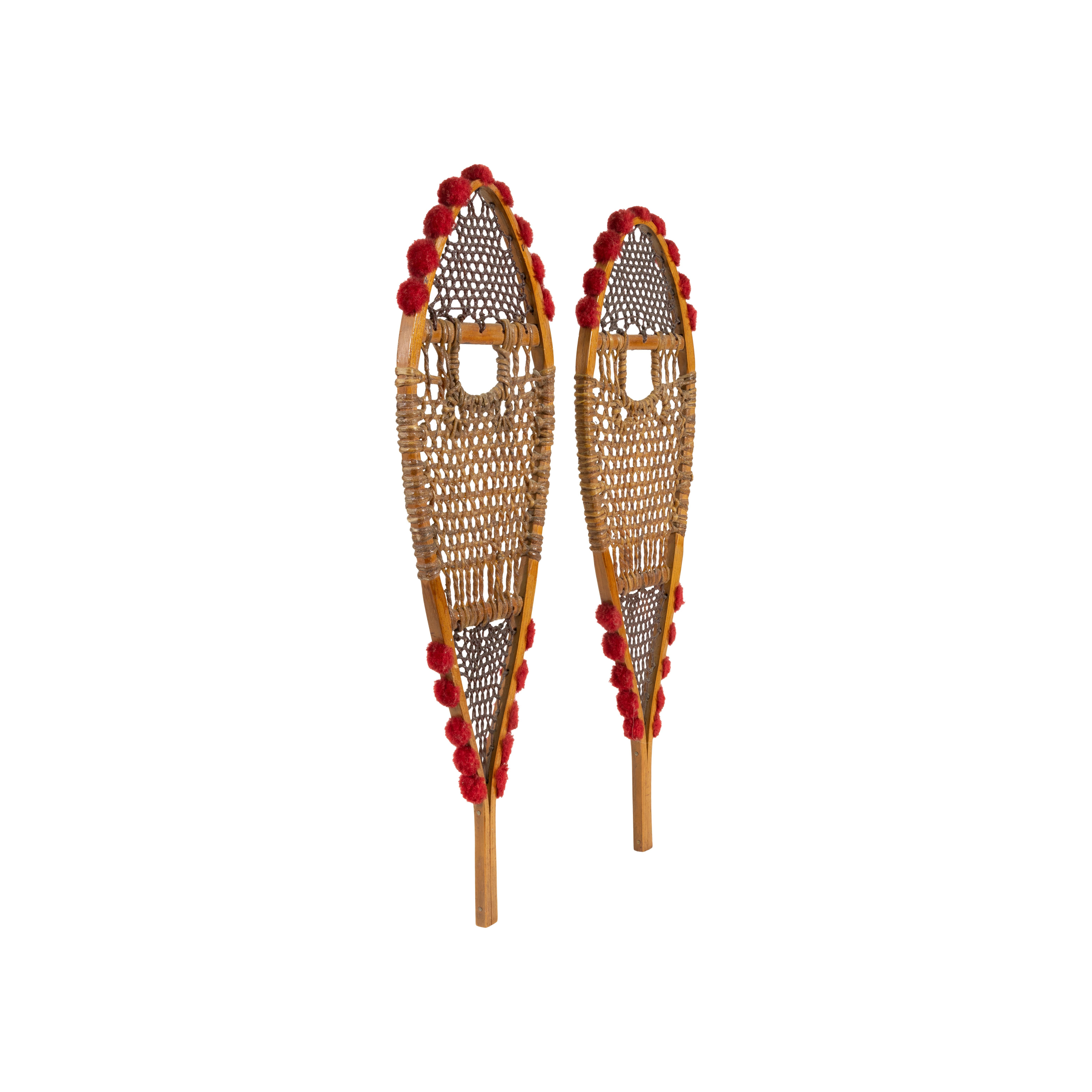 Native American Ojibwe sample snowshoes. White ash with red wool tuffs and finely woven sinew. 
PERIOD: Early 20th Century
ORIGIN: Northeast - Ojibwe, Native American
SIZE: 16