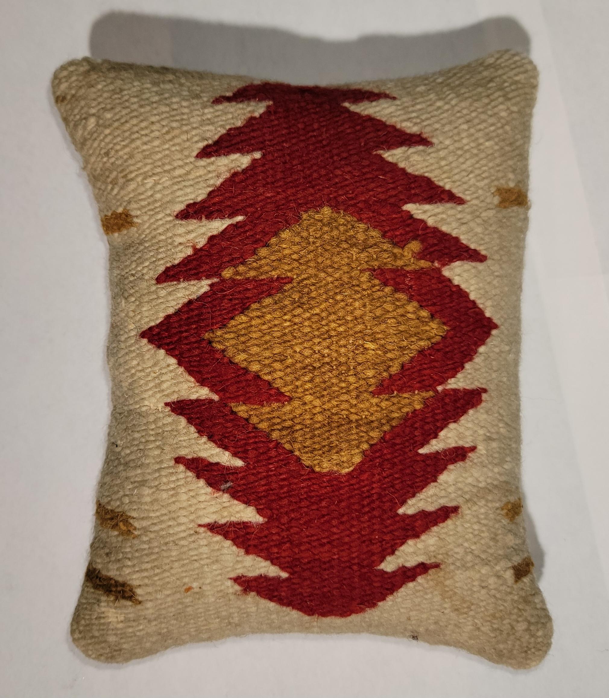 Early 20th Century Navajo sampler eye dazzler pillow with bright reds and yellow color. The backing is a linen backing, Custom made insert with down and feather. Small in stature but strong in its presentation. 