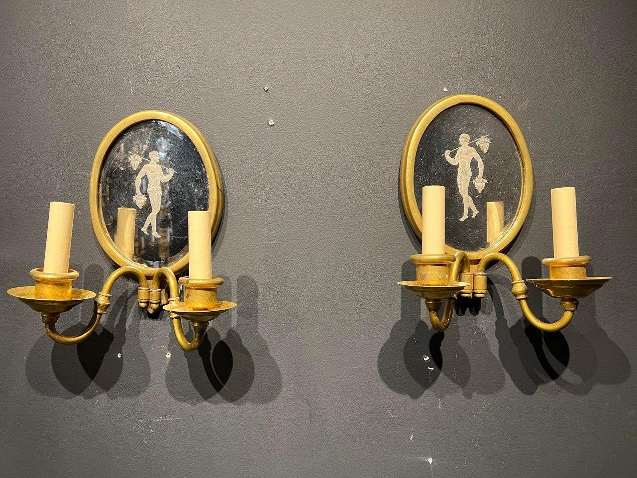 A pair of circa 1920’s Caldwell neoclassic style sconces with edged mirrored back plate