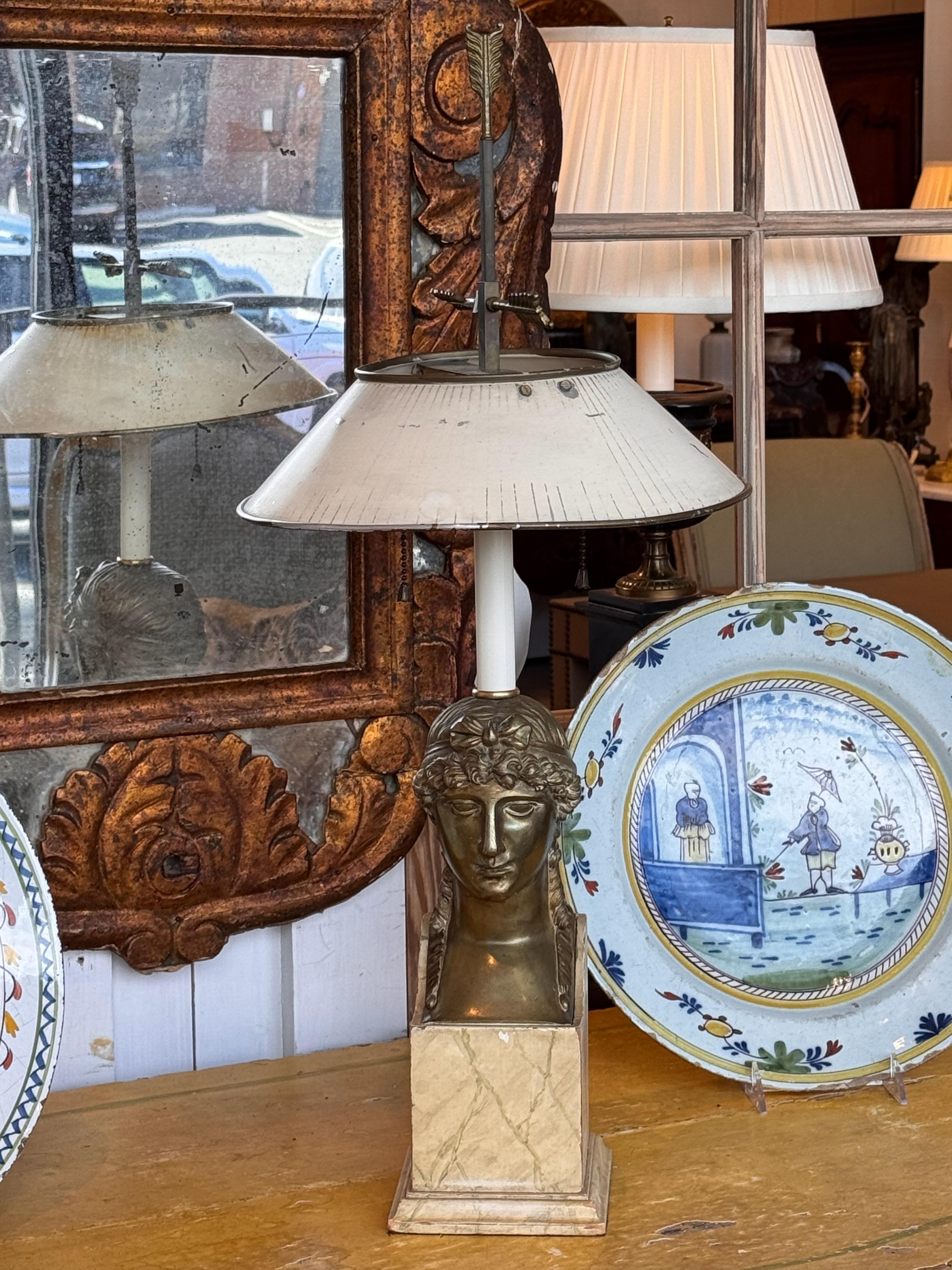 A very neoclassical style lamp. It has a faux marble base and a tole shade.