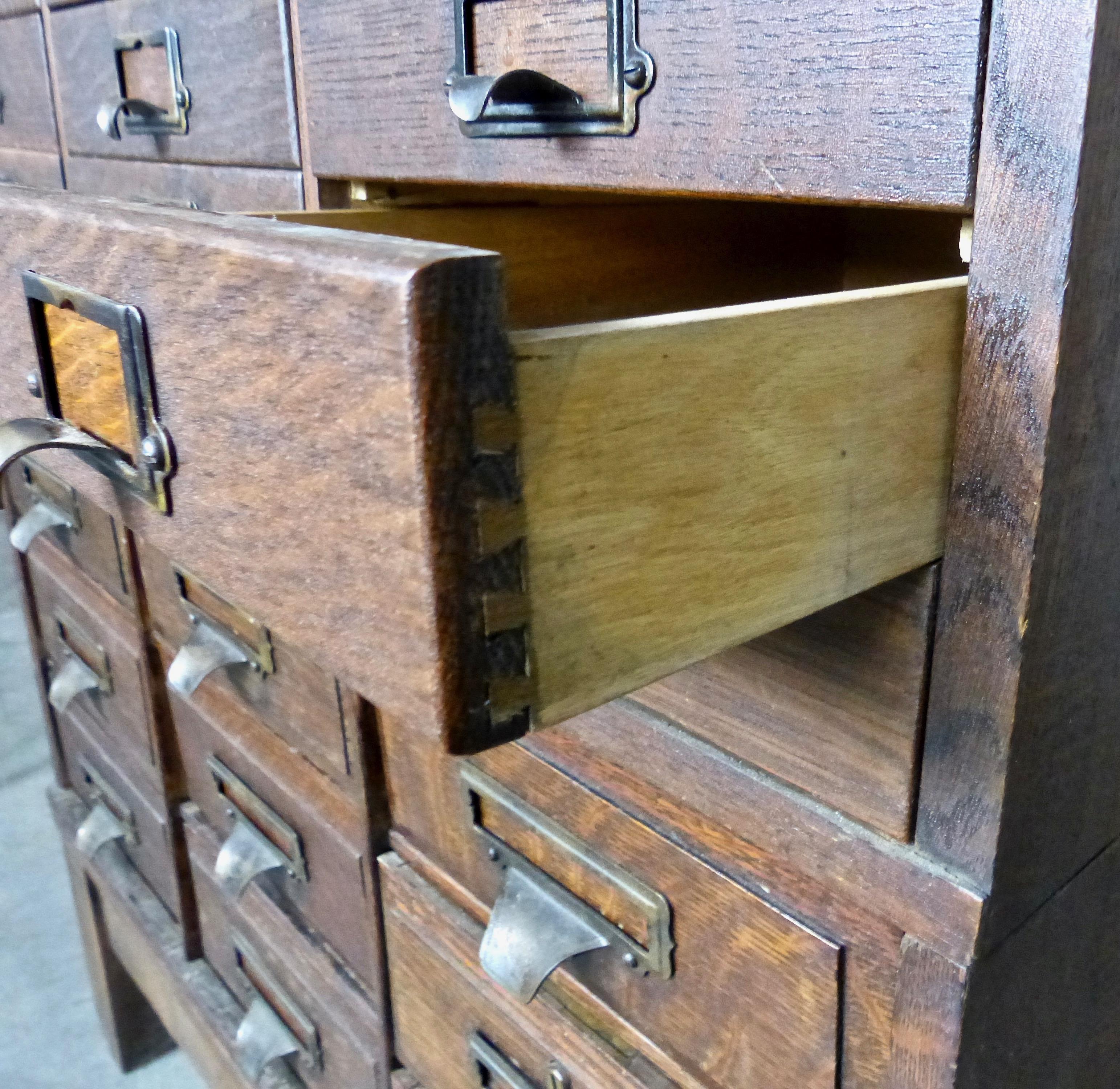 Cleverly designed with individual mix-and-match modules, this oak apothecary cabinet is completely intact (a rarity). Made by The Office Specialty Co., in Newmarket, Ontario, it not only retains its original brass label; each brass drawer pull is