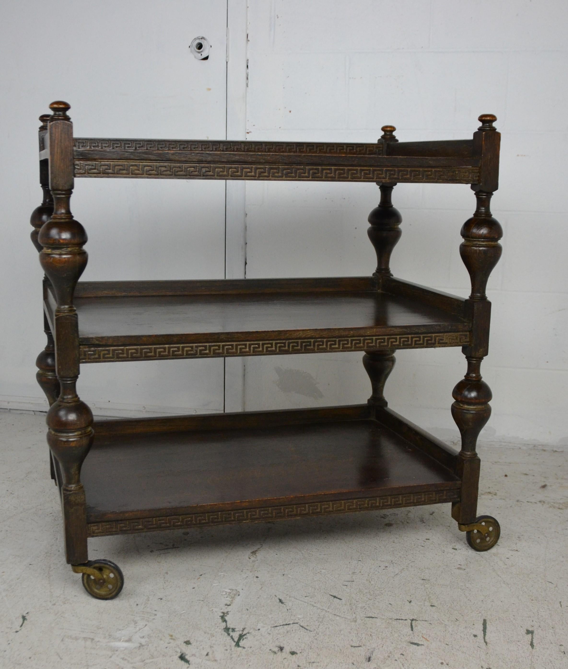 A solid oak tea cart made in England in the mid-1920s. Baluster shape turned uprights. Excellent original finish. Fitted with rubber-tired wheels.