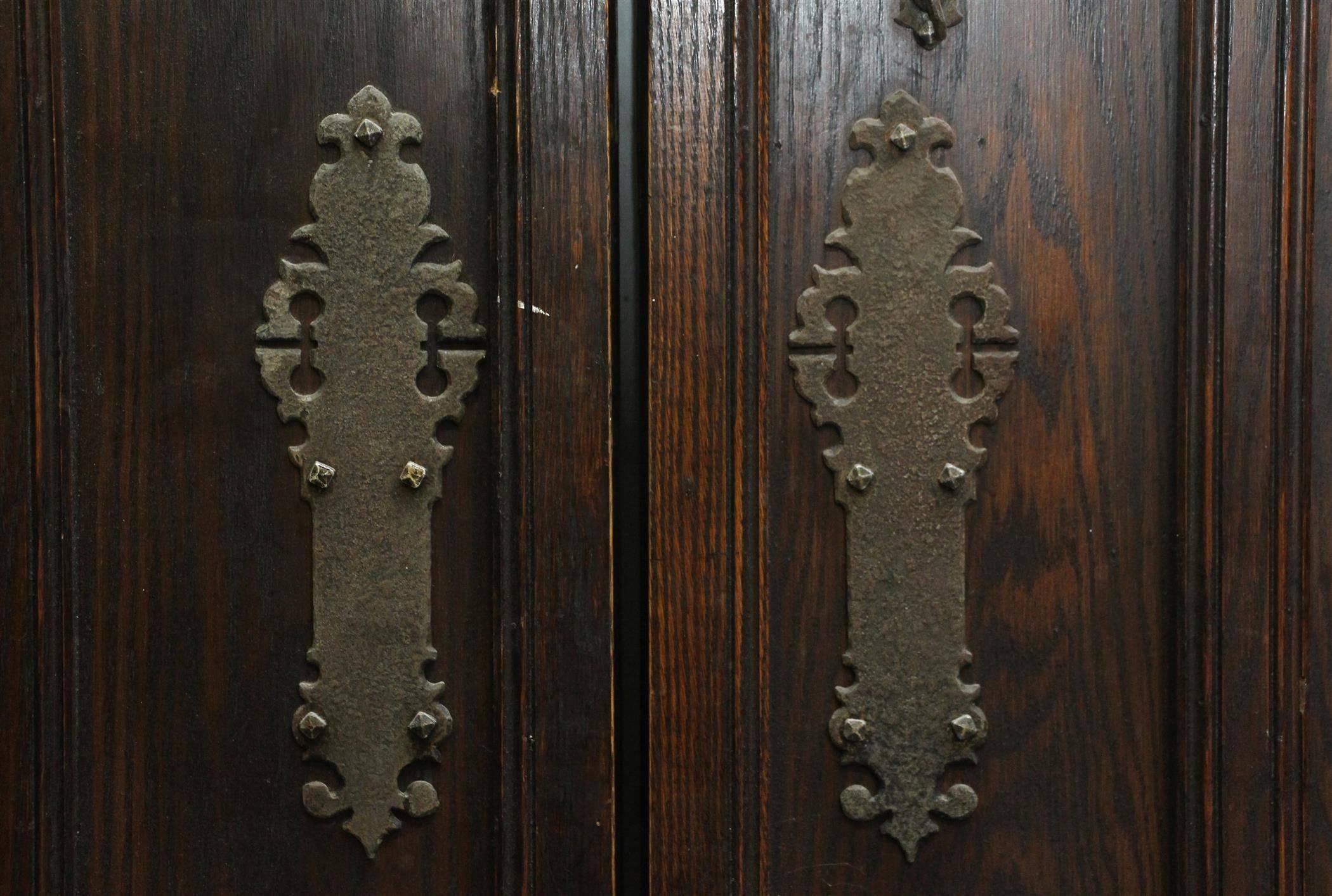 1920s oak double entry doors with a Gothic arch, original leaded glass windows and hardware. The opposite side has fantastic studded details. Good condition. Priced as a pair. Please inquire about a photo complete with transom. This can be seen at
