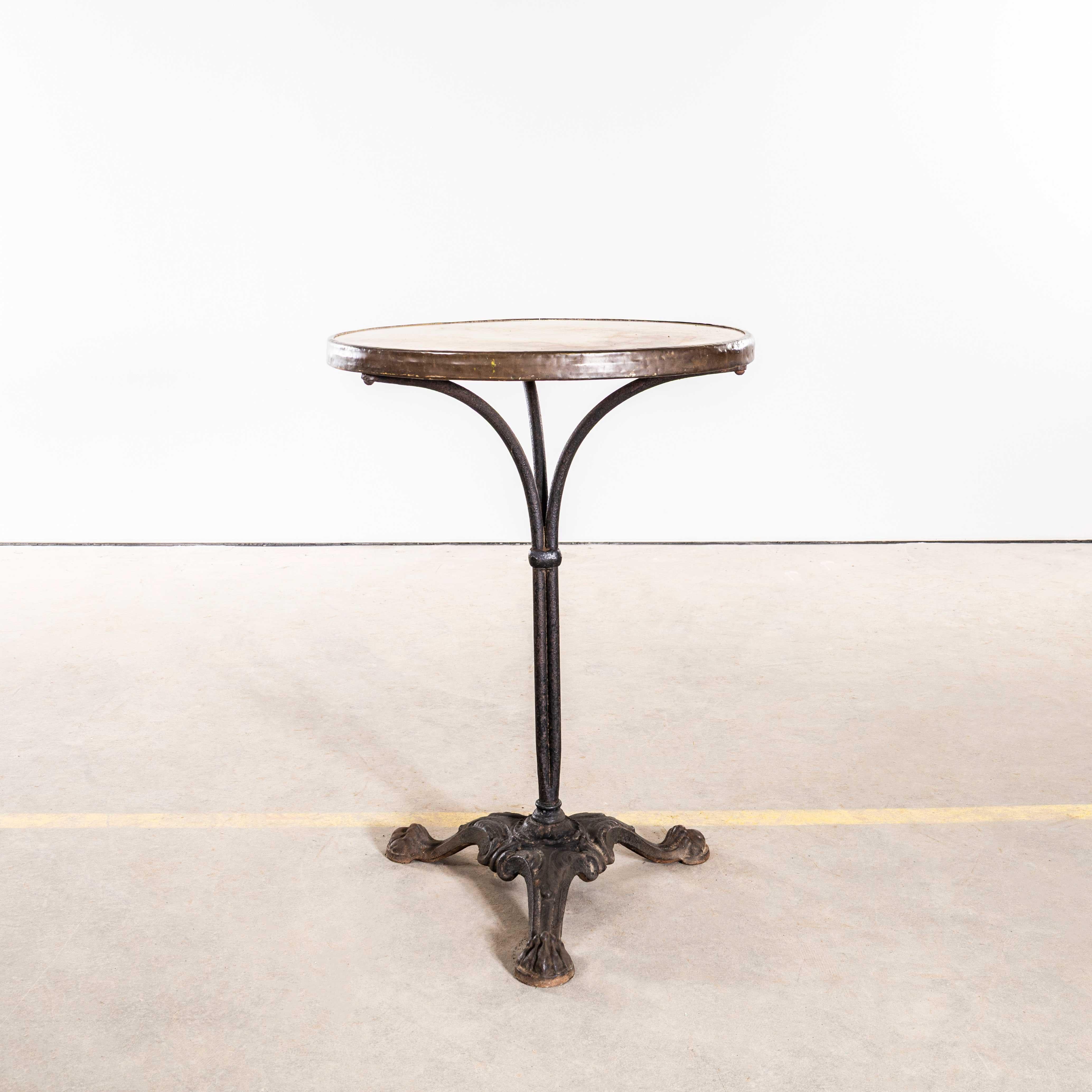 Table de bistrot en fonte d'origine française des années 1920. 
Exceptionnelle table de café en fonte d'origine française, avec un piètement en tiges composé de trois tiges en acier forgé jointes et formées à la main, et fixées par un anneau