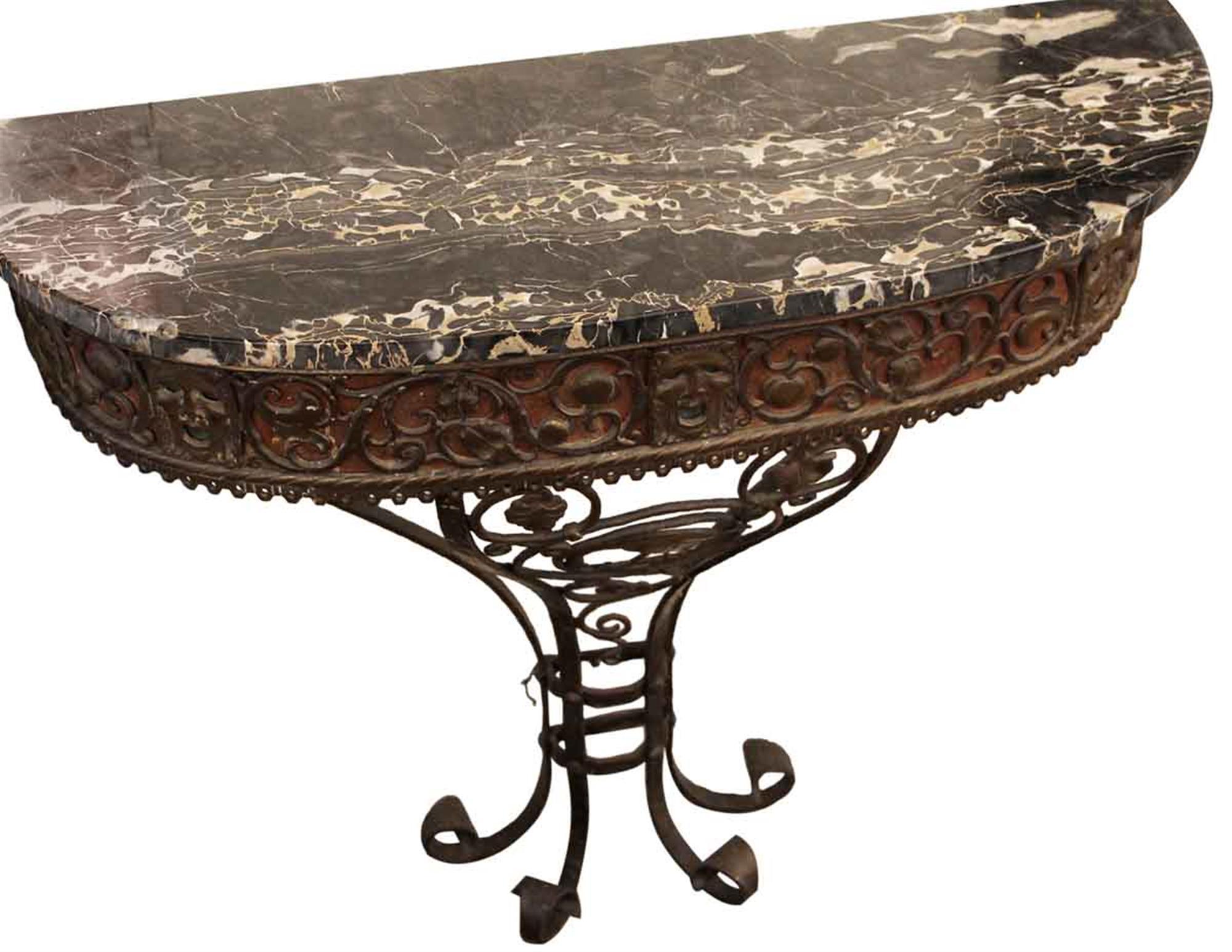 Bronze and wrought iron figural console table with a black marble top designed in an Oscar Bach style. This can be seen at our 2420 Broadway location on the upper west side in Manhattan.