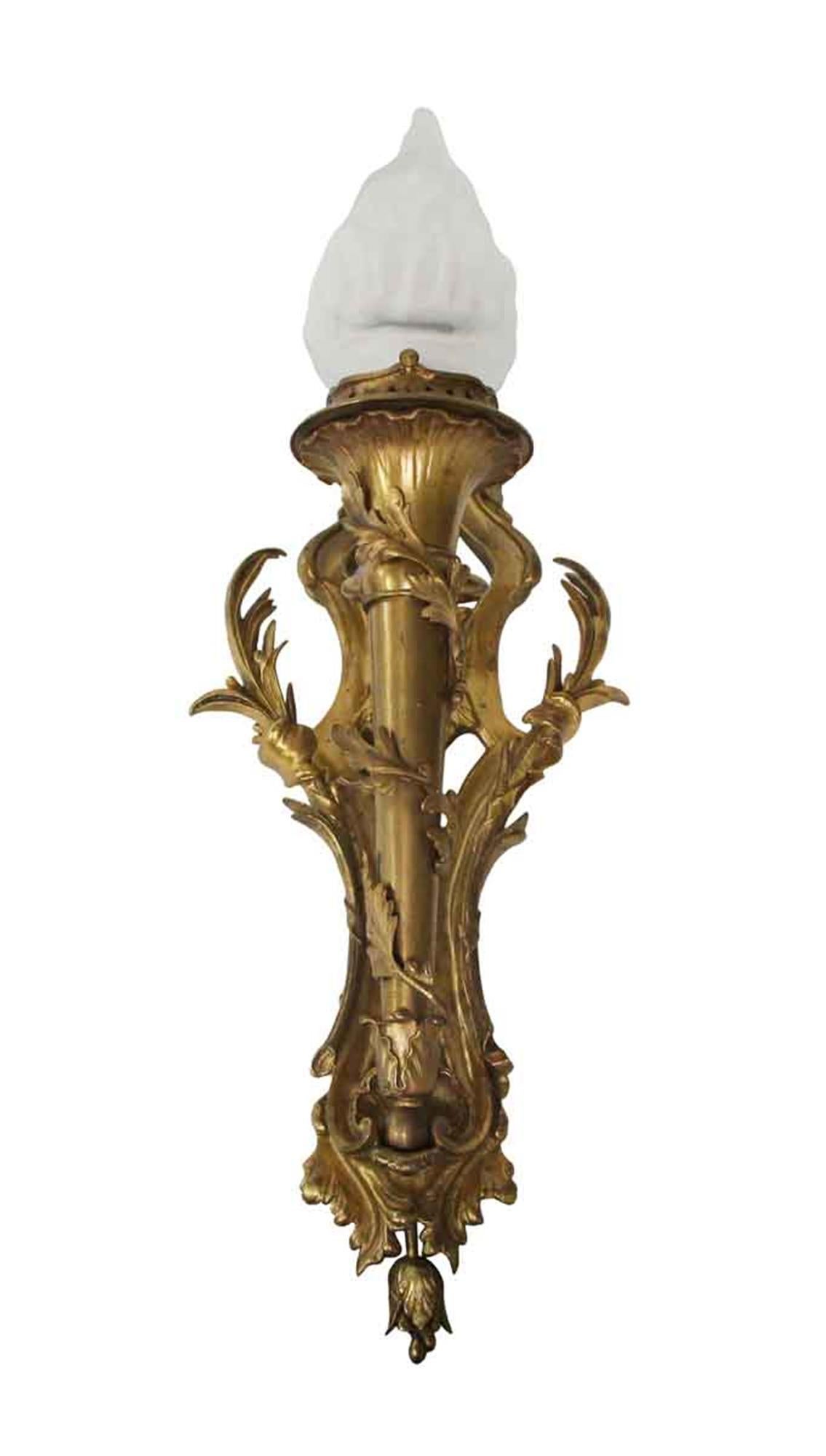 Highly ornate pair of gorgeous gilded bronze sconces with frosted torch flame shades. Priced as a pair. This can be seen at our 302 Bowery location in Manhattan.