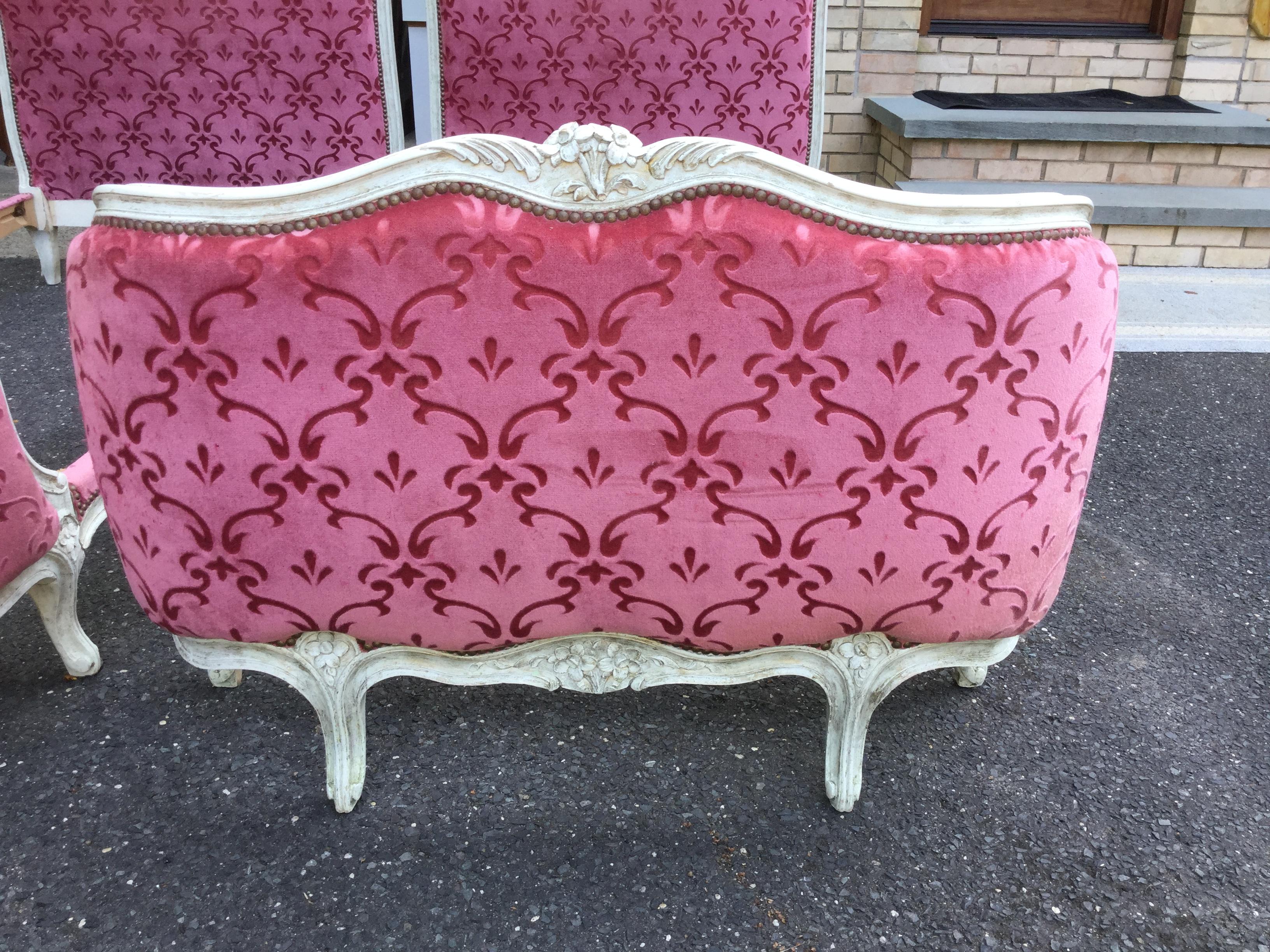 Gorgeous pair of French painted twin beds. Upholstered in a stunning hot pink velvet which has no stains but they do have some slits and scratches on the head board and foot board. The painted carved wood frame is cream with gold brush strokes that