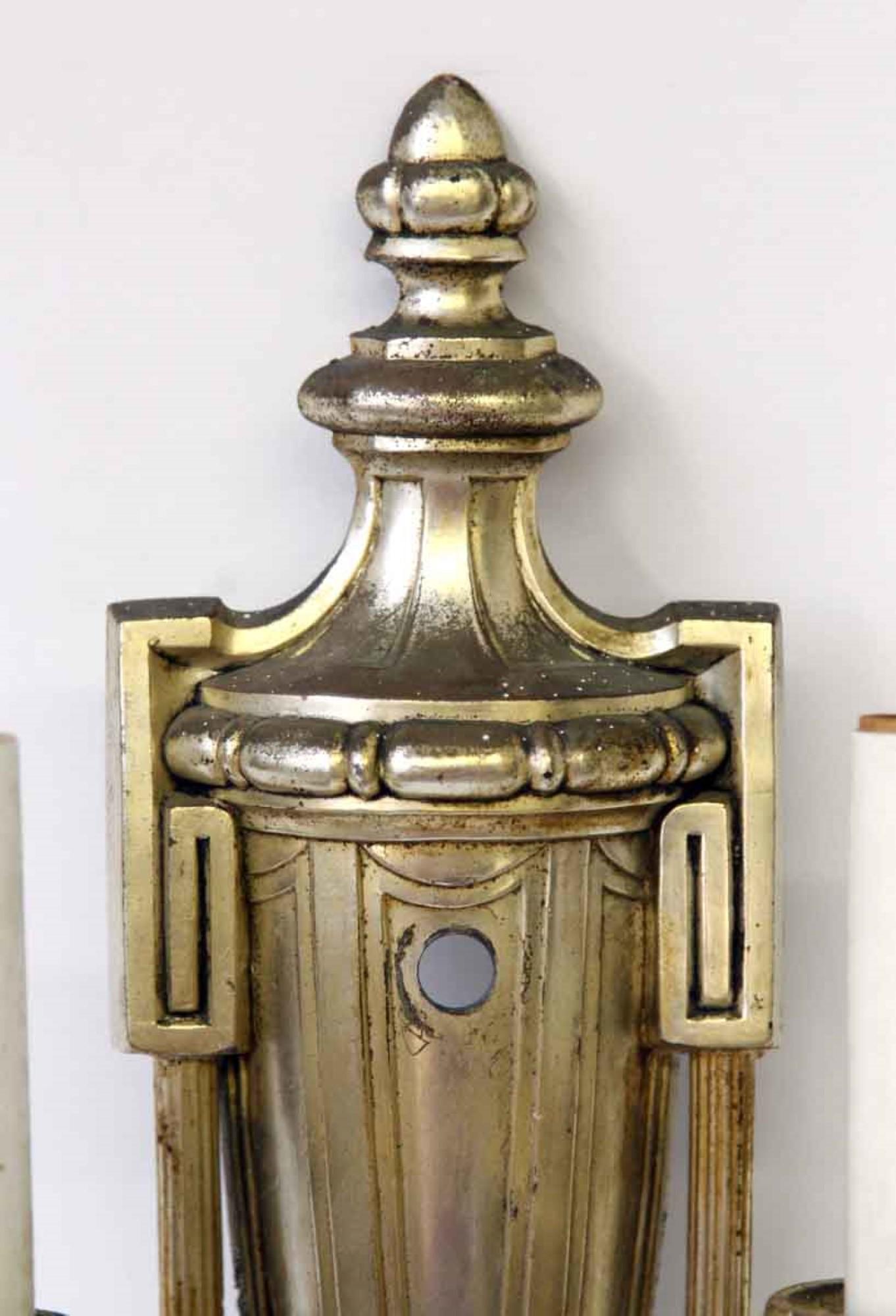 American made neoclassical brass silvered sconces with casting details on the bobeches, cup and back plate. Classic urn and Greek key detail grace these stately wall sconces. Priced as a pair. This can be seen at our 400 Gilligan St location in