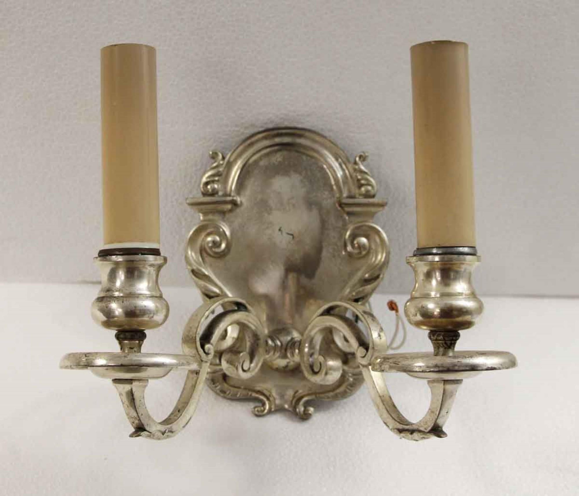 1920s two arm brass candlestick sconces with a silver plated finish. Priced as a pair. Small quantity available at time of posting. Please inquire. This can be seen at our 400 Gilligan St location in Scranton, PA.