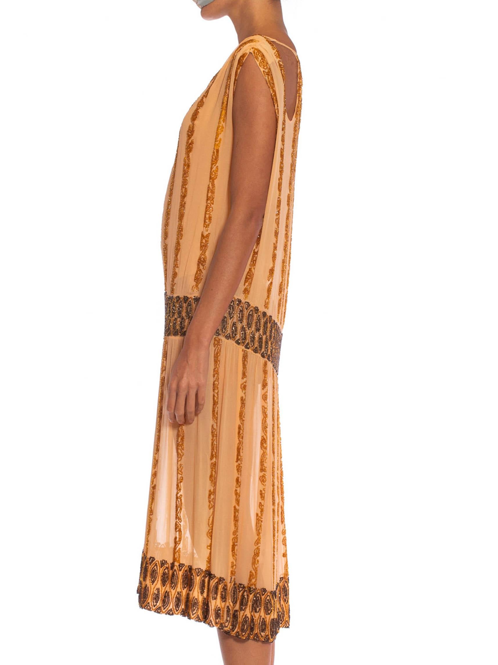 In great soft and strong wearable condition. In a rare and unique color.  1920S Peach Silk Chiffon Beaded In Amber & Metallic Brown Cocktail Dress With Cut Out Neckline 