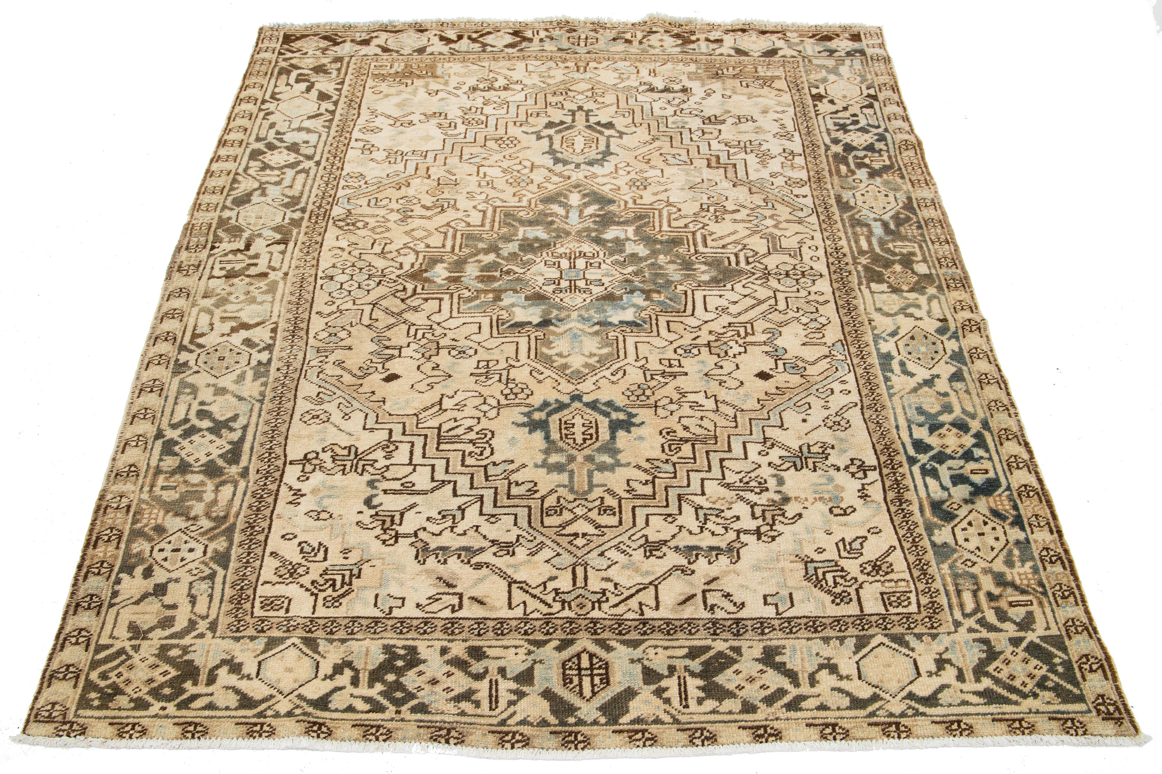 A hand-knotted wool antique Persian Heriz rug with a blue and brown all-over pattern on a beige field.

This rug measures 6'5' x 8'6