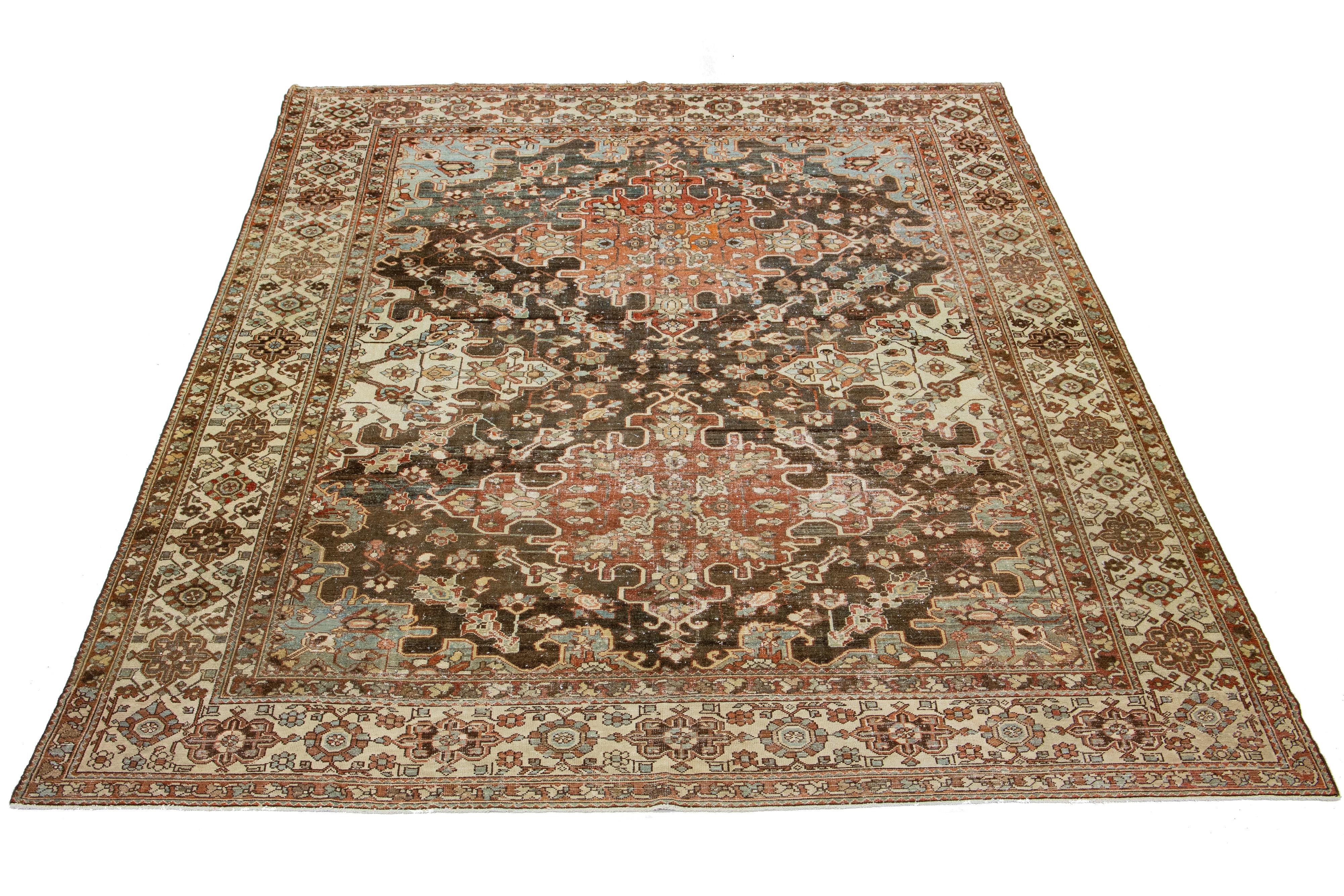 This is a beautiful Antique Bakhtiari hand-knotted wool rug with a brown-colored field. The Persian rug features classic floral patterns with blue, brown, and rust hues.

This rug measures 10'8