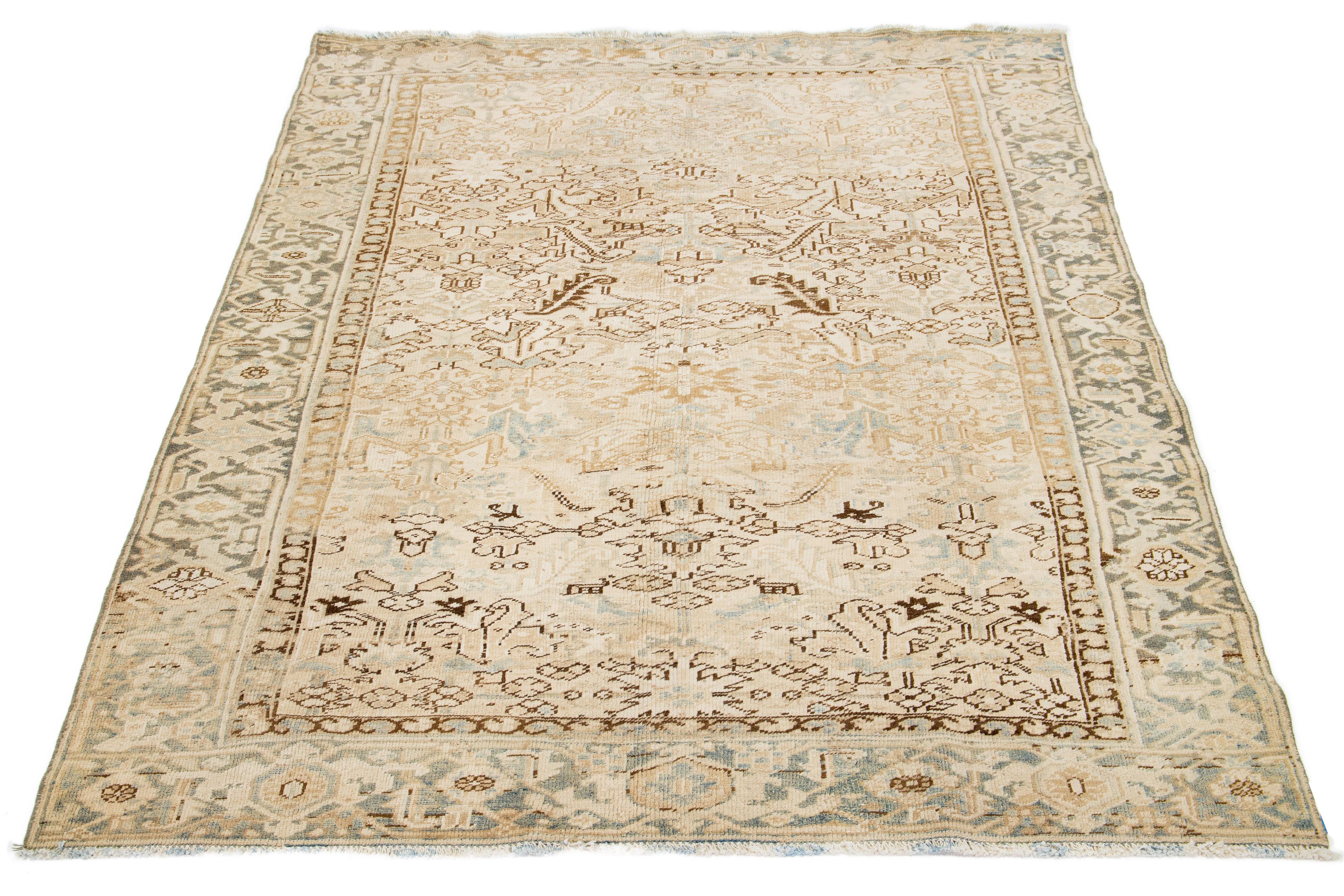 An antique Heriz rug from Persia features a beige field with a blue and brown all-over pattern, hand-knotted using wool.

This rug measures 6'9' x 9'1
