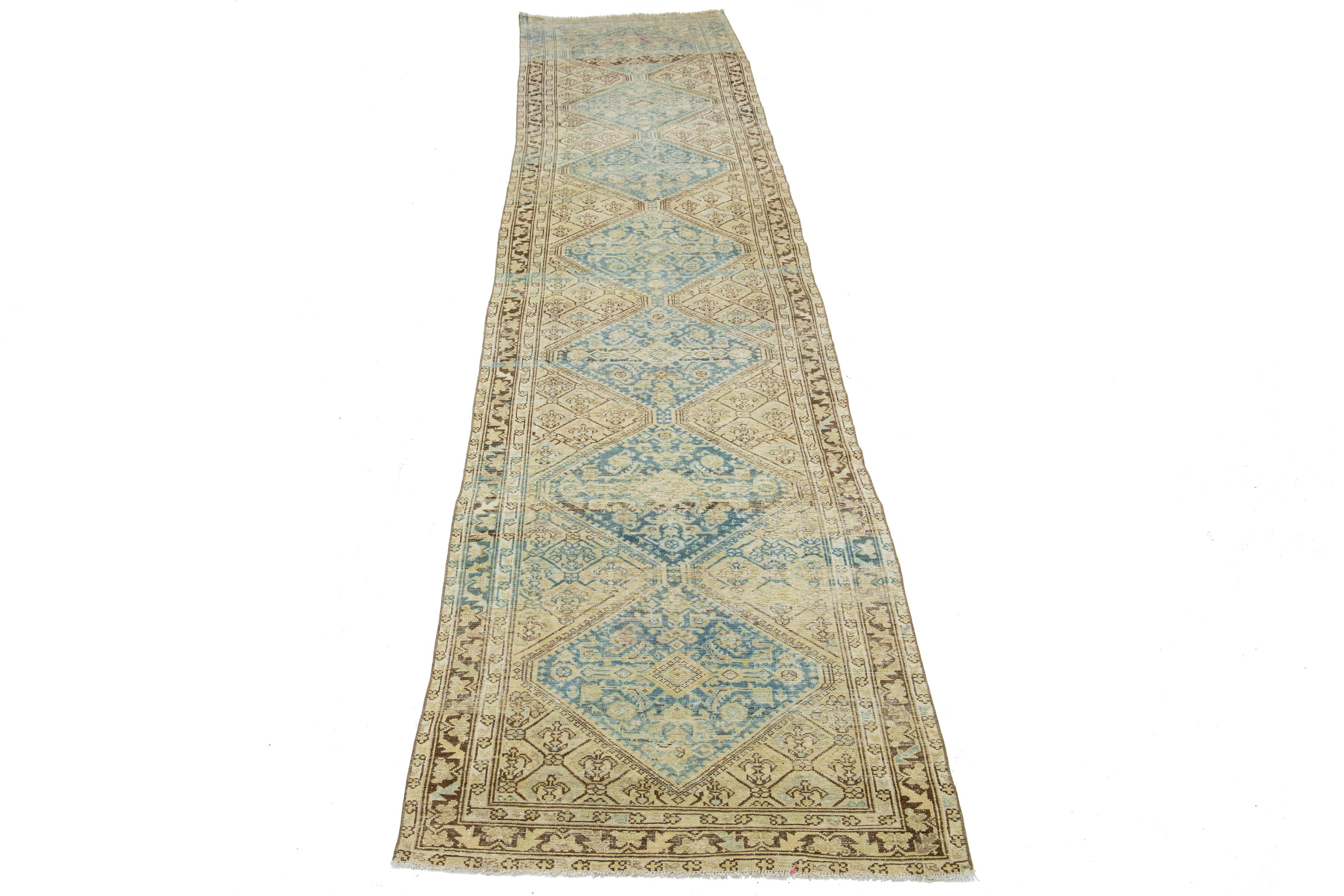 Beautiful antique Malayer Persian runner rug with a beige field. This piece has light blue accents with an all-over tribal floral design. 

This rug measures 3'3