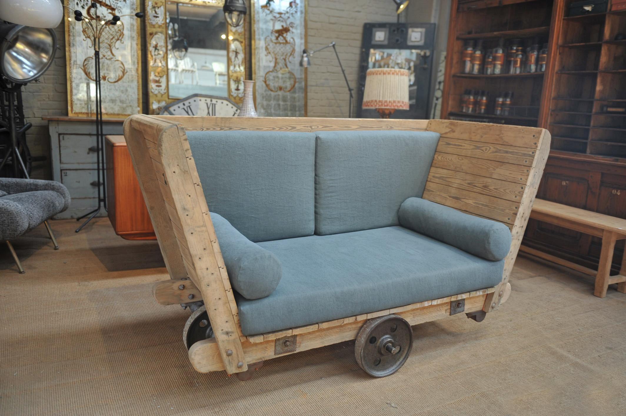 1920s Pine with four iron wheel French Factory Trolley Reupholstered in two-seat sofa new grey fabric.
    