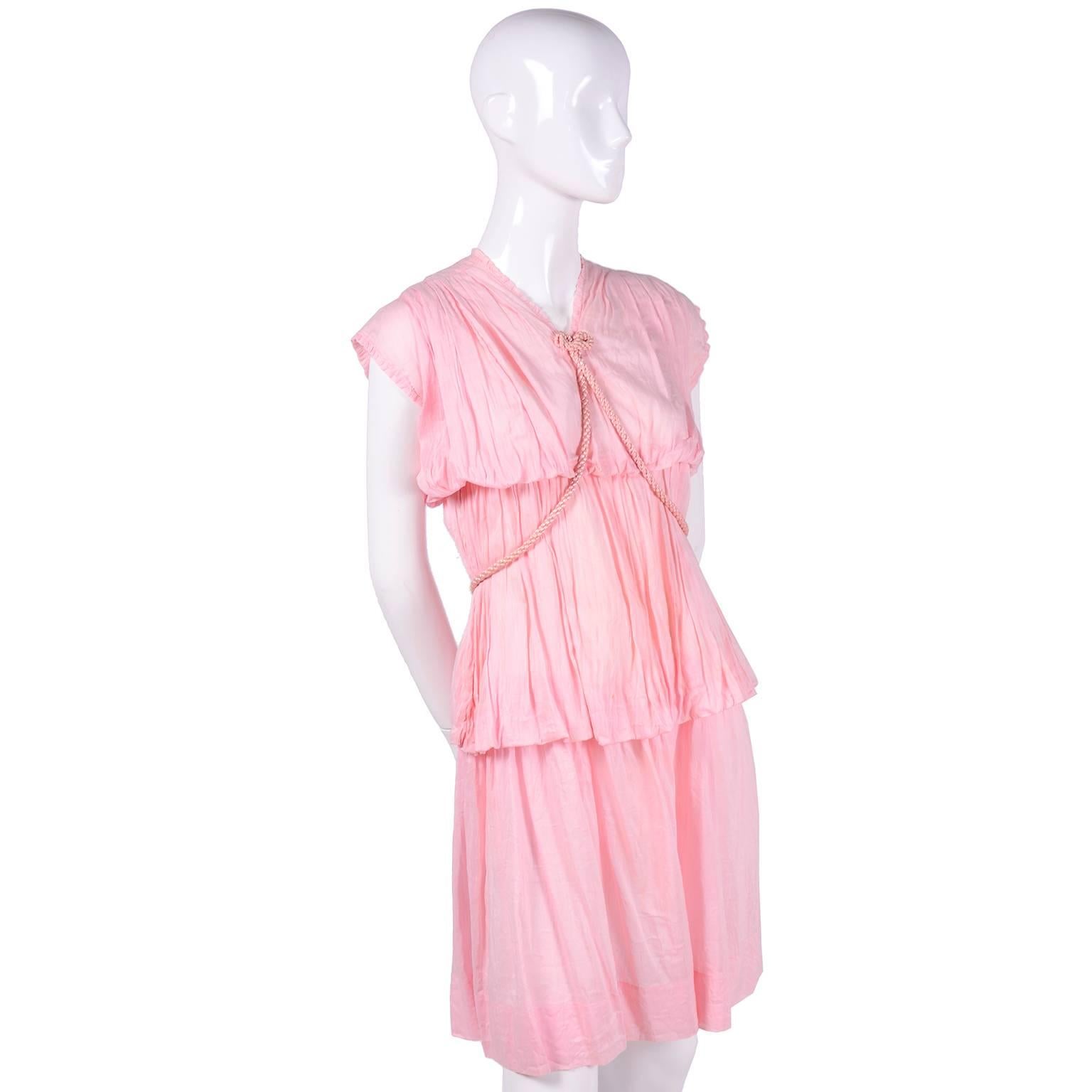 Dies ist ein absolut schönes Vintage-Kleid aus den 1920er Jahren. Das Kleid  ist aus einem rosa, ultrafeinen Baumwoll-Voile mit leicht gerafftem Stoff und einem geflochtenen rosa Satin-Seilgürtel. Der Gürtel kann im griechischen Stil oder auf