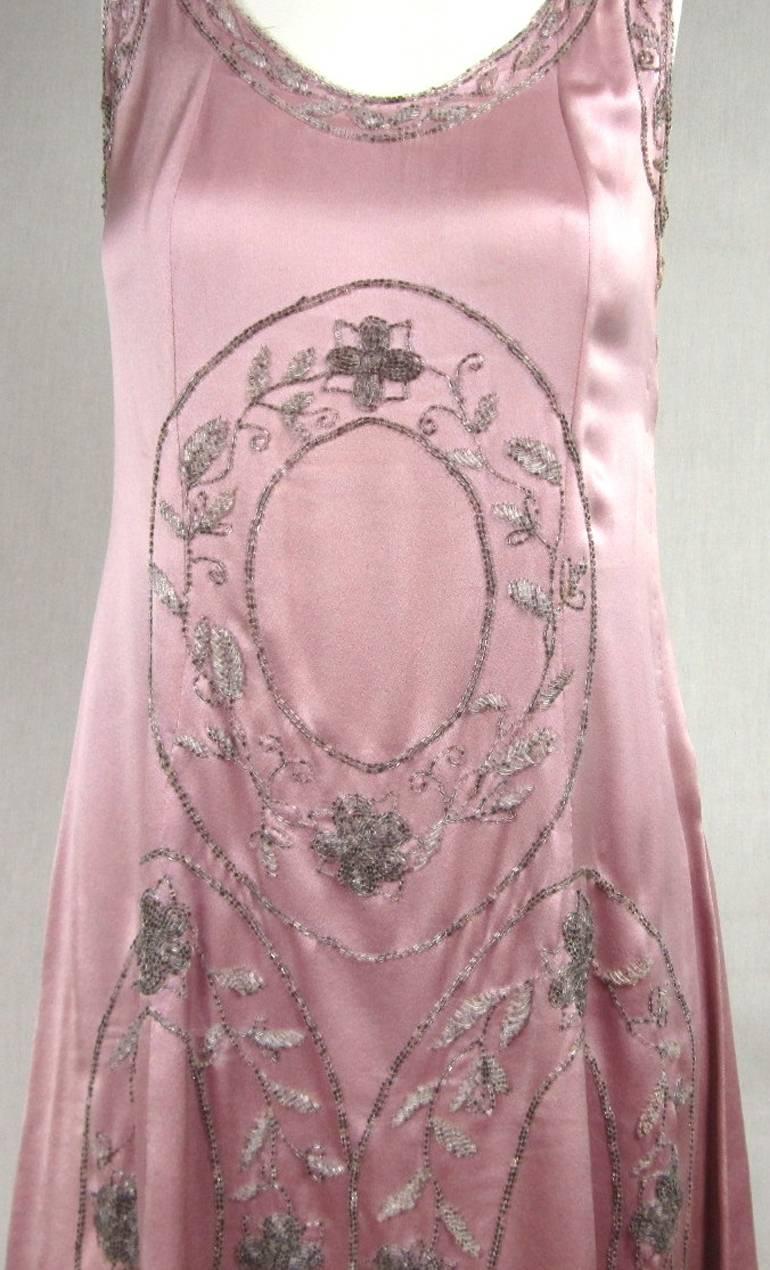 They are getting harder to find, and even harder to find in wearable condition. This silk pink dream is all hand beaded. Stunning T back. Bugle beading around the neckline and arms. Snaps up the left side, no slip needed. Will fit a medium. It was
