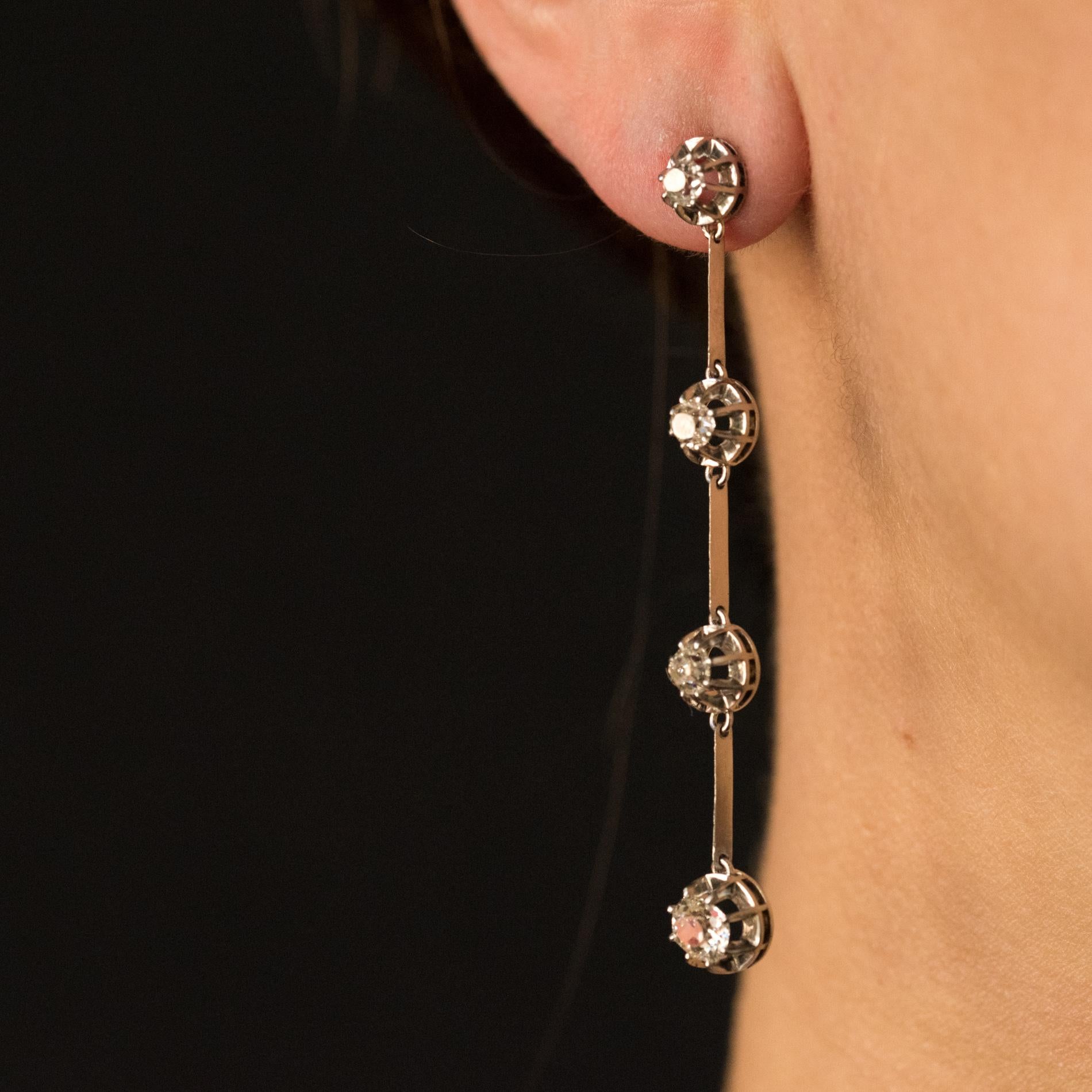 Pair of dangle earrings in platinum and 18 karats white gold.
Sumptuous antique ears pendants, each one is set with a drop cushion- cut diamonds set with claws, each pattern is retained by a knife. The clasp is an alpa system.
Total weight of