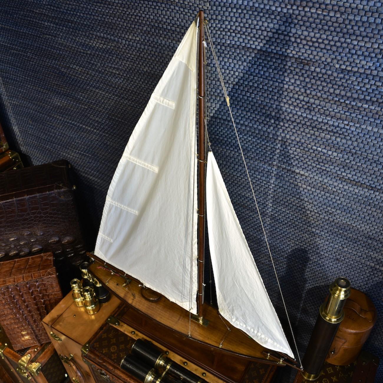 Sleek 1920s bermudan-rigged 30 inch pond yacht with balanced main sail steering gear and lead keel. The sails are copies of the originals and the model sits on a newly made stand using old timber.

A main sheet steering mechanism uses balance gear,