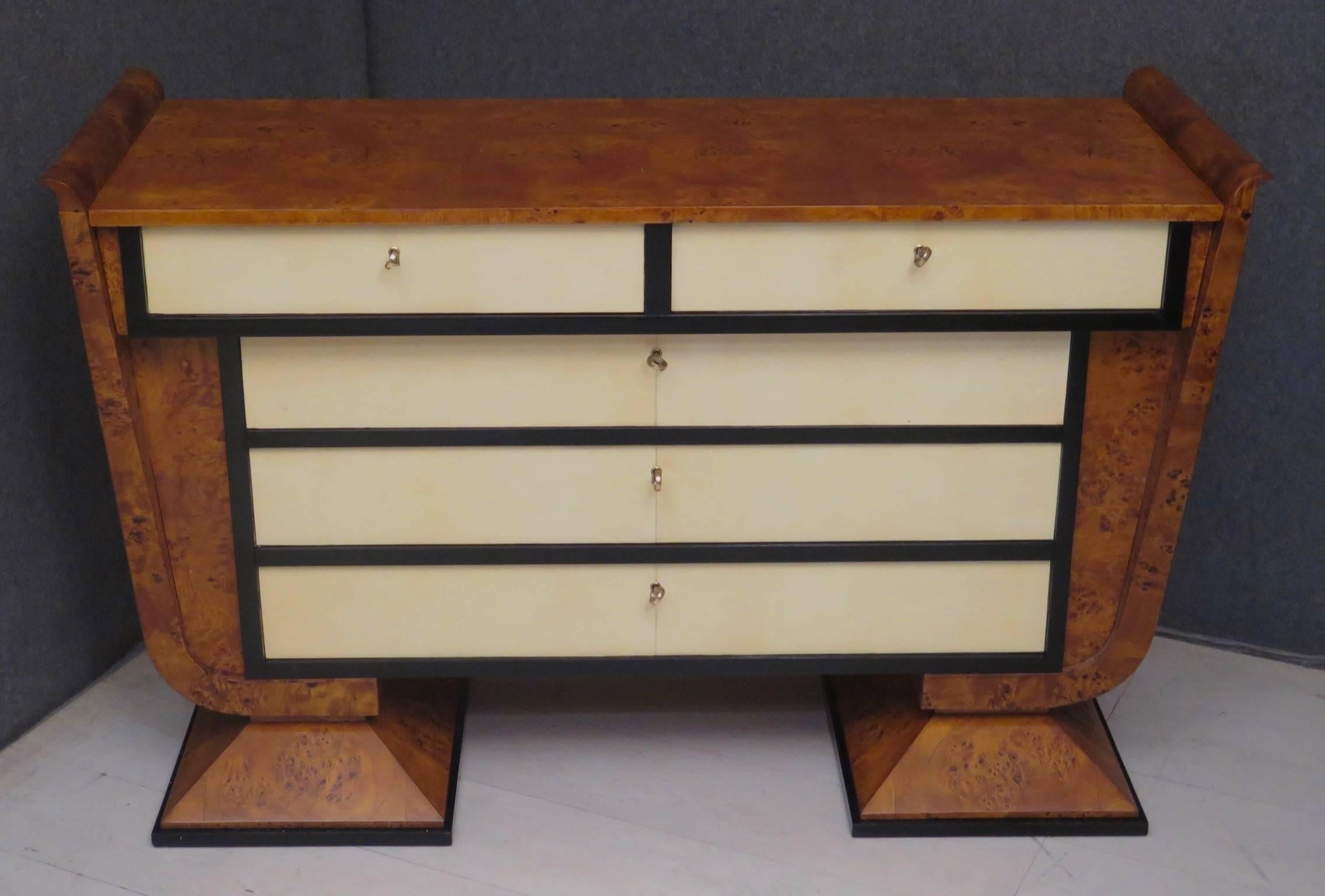Italian Art Deco dresser. Body all veneered in poplar burl. On the front the five drawers instead are covered in parchment leather. The drawers, as we can see from the photos, all around have a black lacquer frame. It can be opened by means of a key