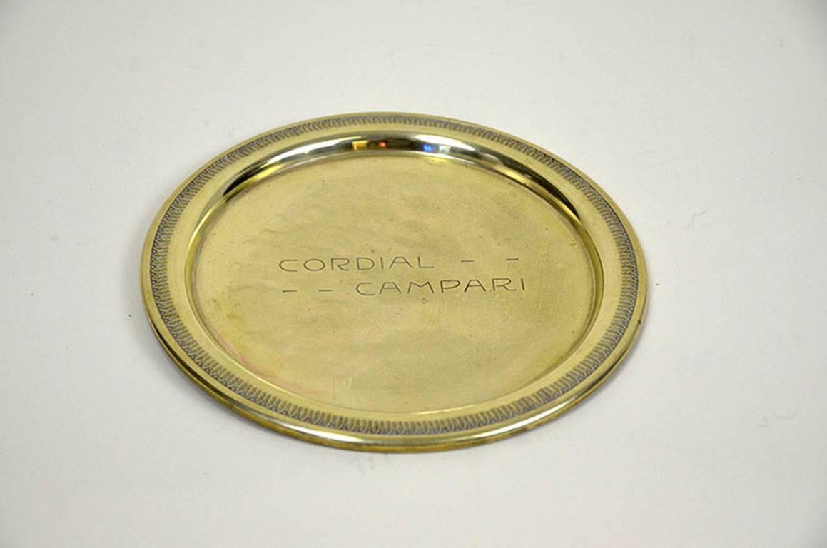 Rare vintage cordial Campari brass tray made in Italy in the 1920s.

The tray is engraved cordial Campari and presents a geometric frieze around the border.

Collector's note:

Cordial Campari, a Raspberry flavoured liqueur, was introduced in