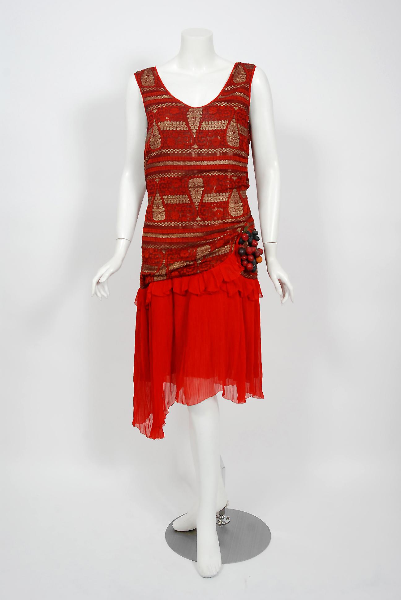 Breathtaking 1920's flapper dance dress in the prettiest metallic gold and red color combination. The garment's simple unstructured style is so modern; the fine couture fabrics are a treasure trove of needle art. The dress is fashioned from