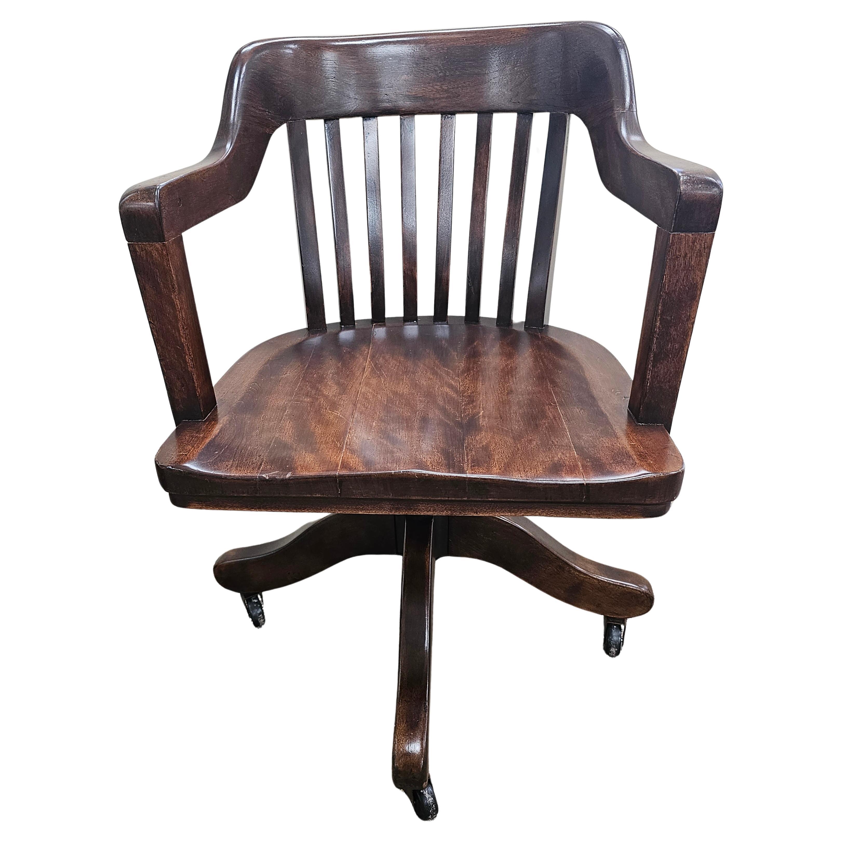 A 1920s freshly and professionally Refinished Walnut Swivelling And Tilting Rolling Banker's Office Chair. Fully functional. Rooling great. Swivelling Great and tighly tilting great. Great antique condition. Measures 23