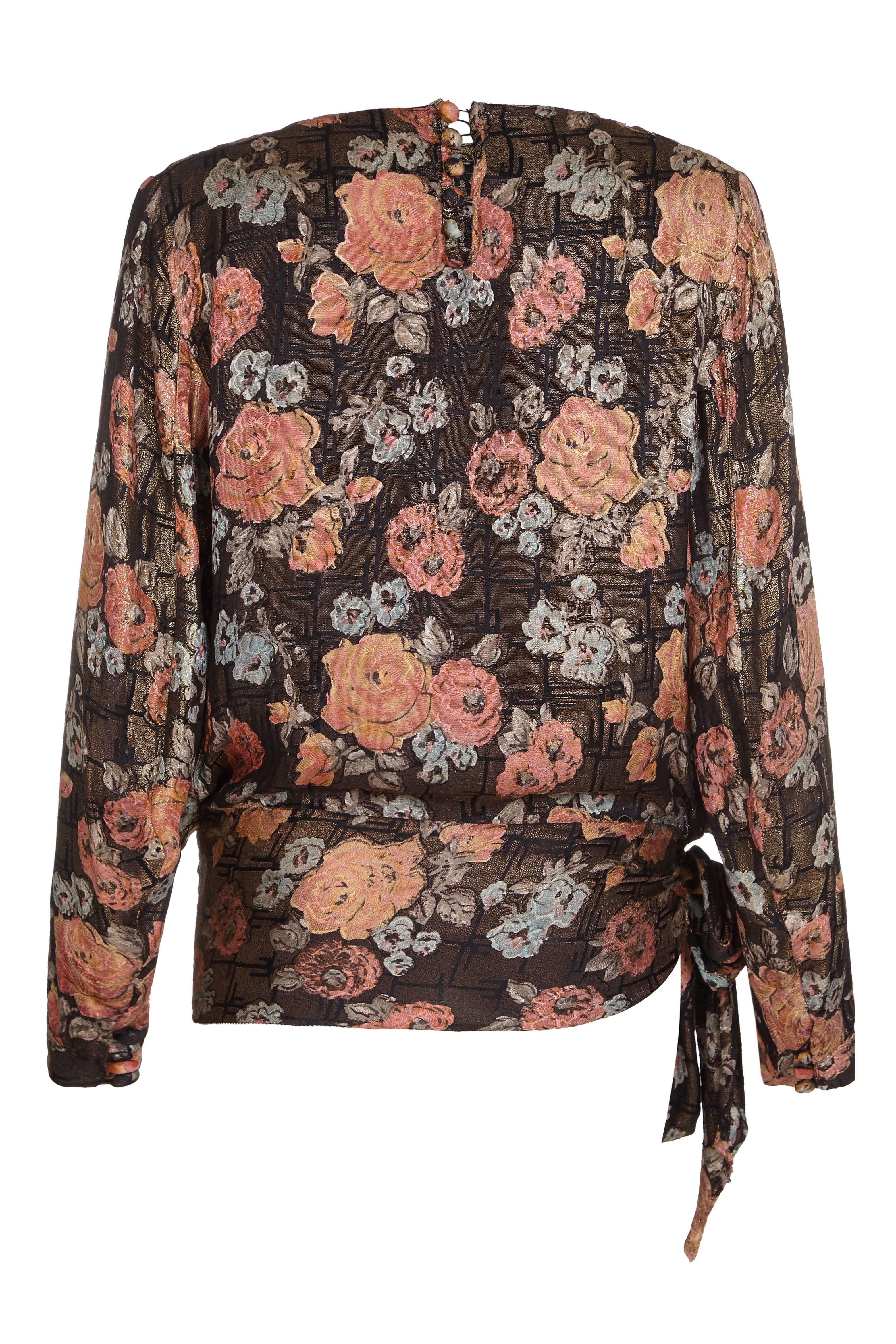 This desirable 1920s gold lamé blouse with a pretty rose print in soft peach, pale blue and grey tones over an abstract black and gold deco background is in excellent vintage condition although the designer is unknown. It features a lengthly sash