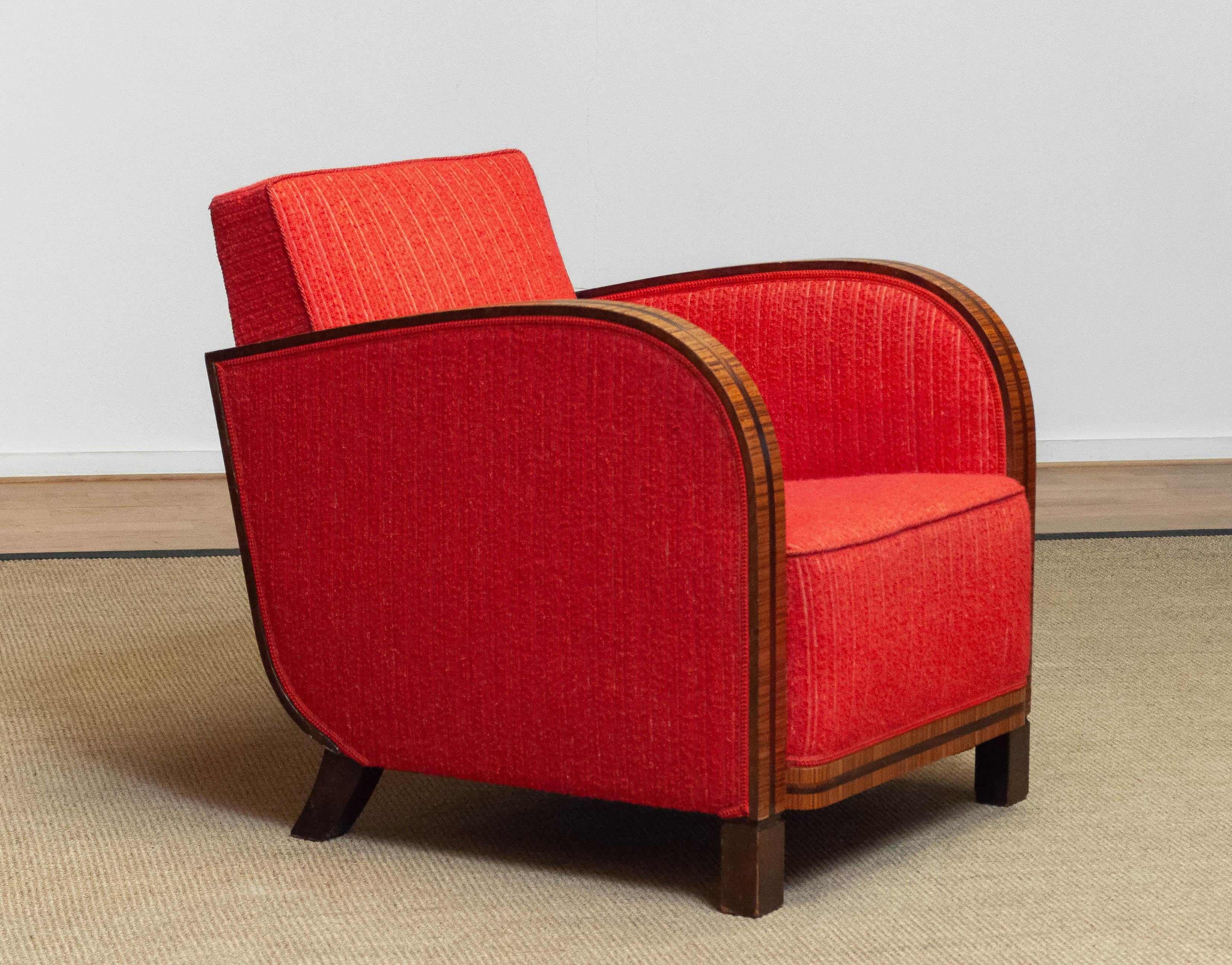 Absolutely beautiful and rare club / lounge chair in good and original condition. The red bouclé fabric is still in good and clean condition. All springs and bindings are also in good condition and therefor supports very comfortable. The veneered