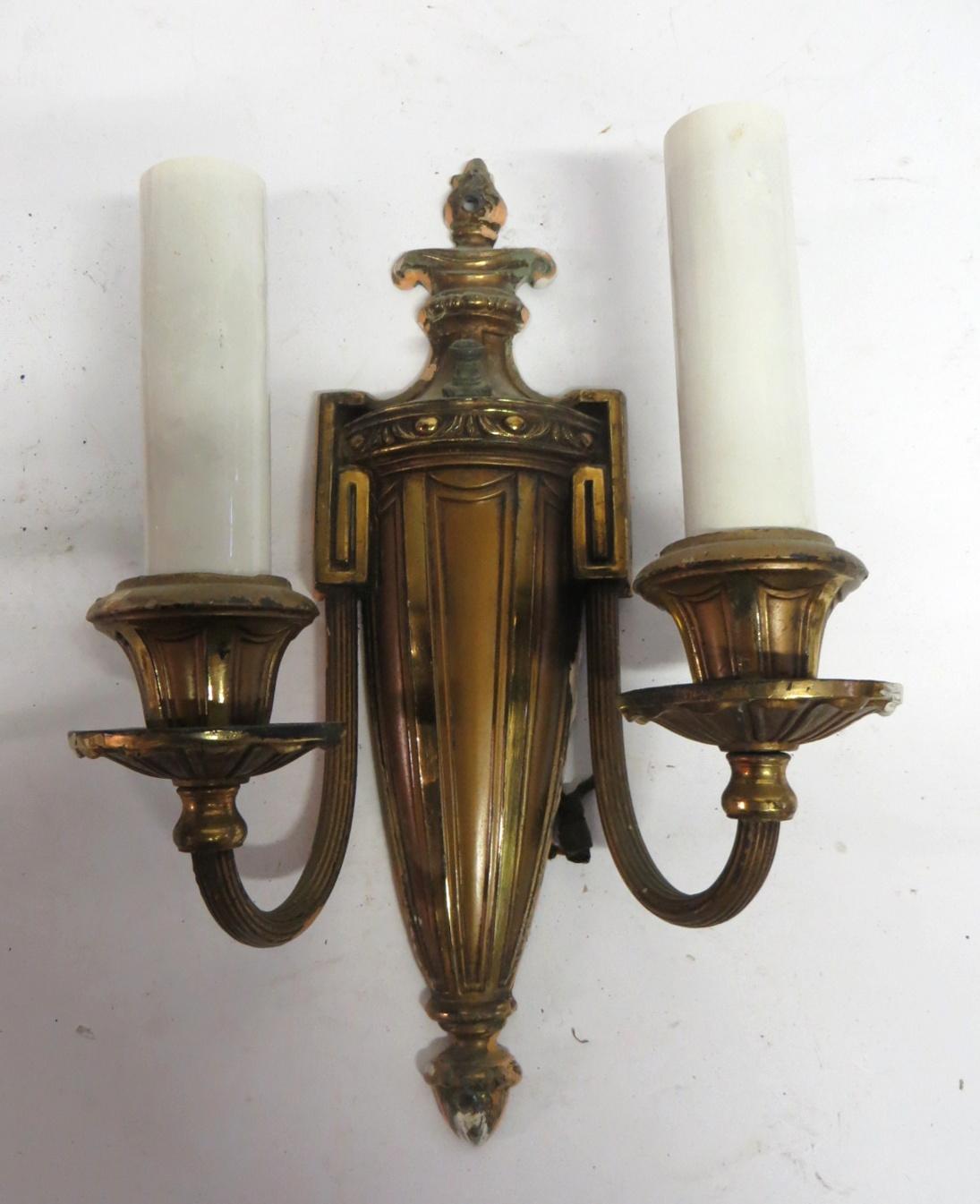 Vintage neoclassical style two-arm brass scones with a flame and acorn finial motif and Greek key shoulder design, circa 1920. Price includes cleaning, repair and wiring. Please allow 1-2 weeks for processing. Priced as a set. These can be seen at