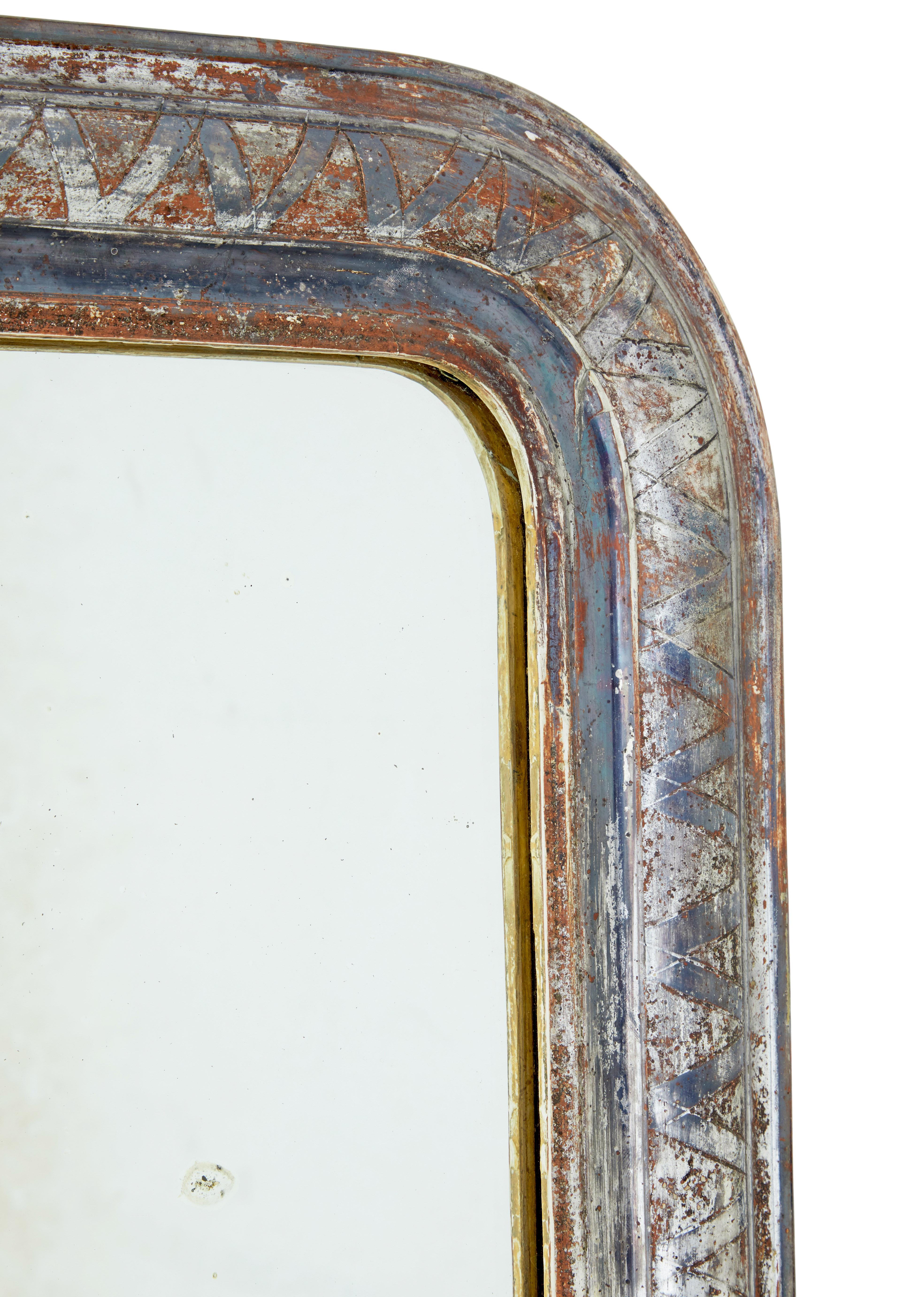 Silver gilt patterned wall mirror, circa 1920.

Originally decorated with silver gilt which has since been rubbed back to its current distressed appearance. Rounded top edge with shaped slip.

Expected minor plate losses to mirror, marks to wood