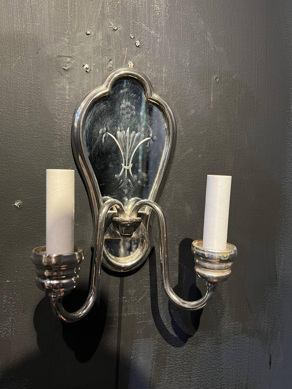A pair of circa 1920’s Caldwell silver plated and etched mirror backplate sconces with two lights