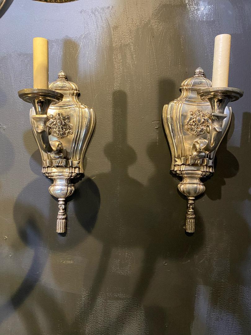 A pair of circa 1920's Caldwell one light sconces with rampant lions on backplate.