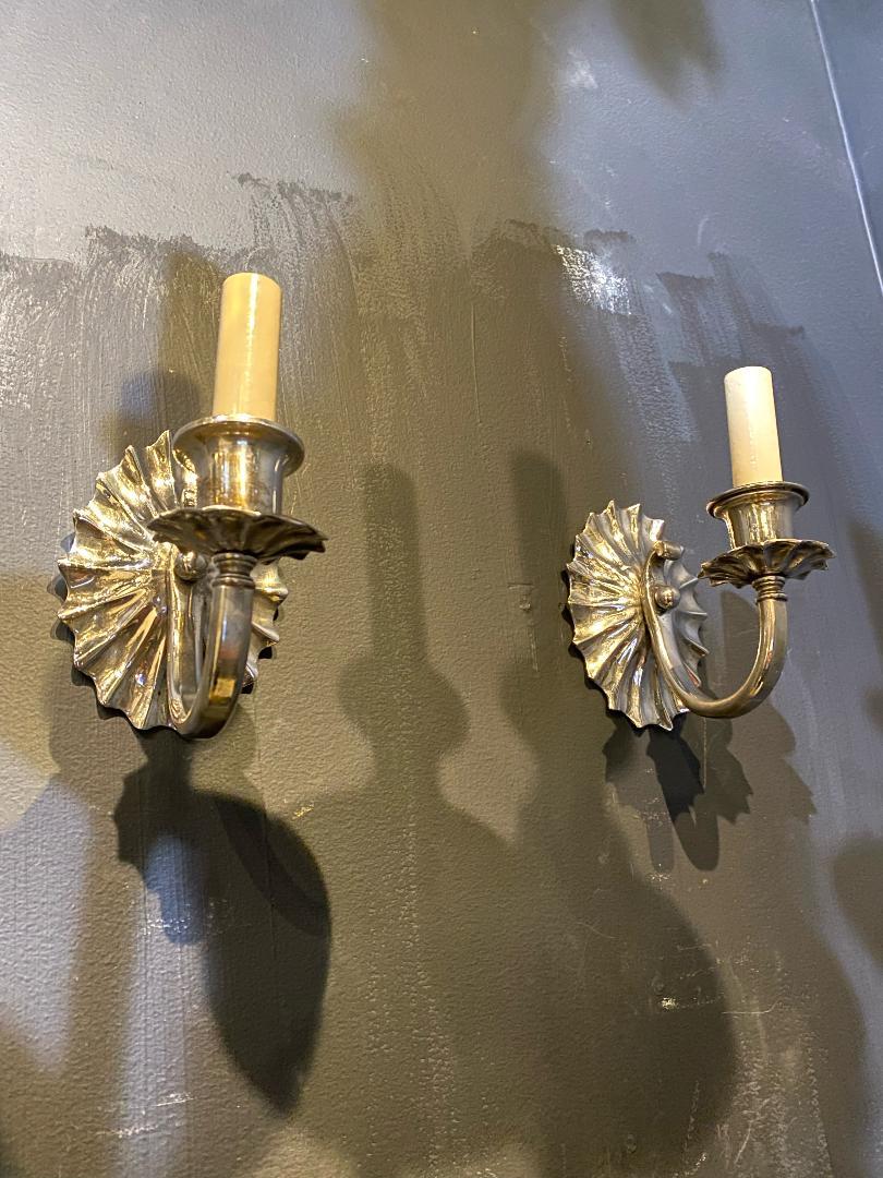 A pair of circa 1920's Caldwell one light sconces with scalloped backplate
