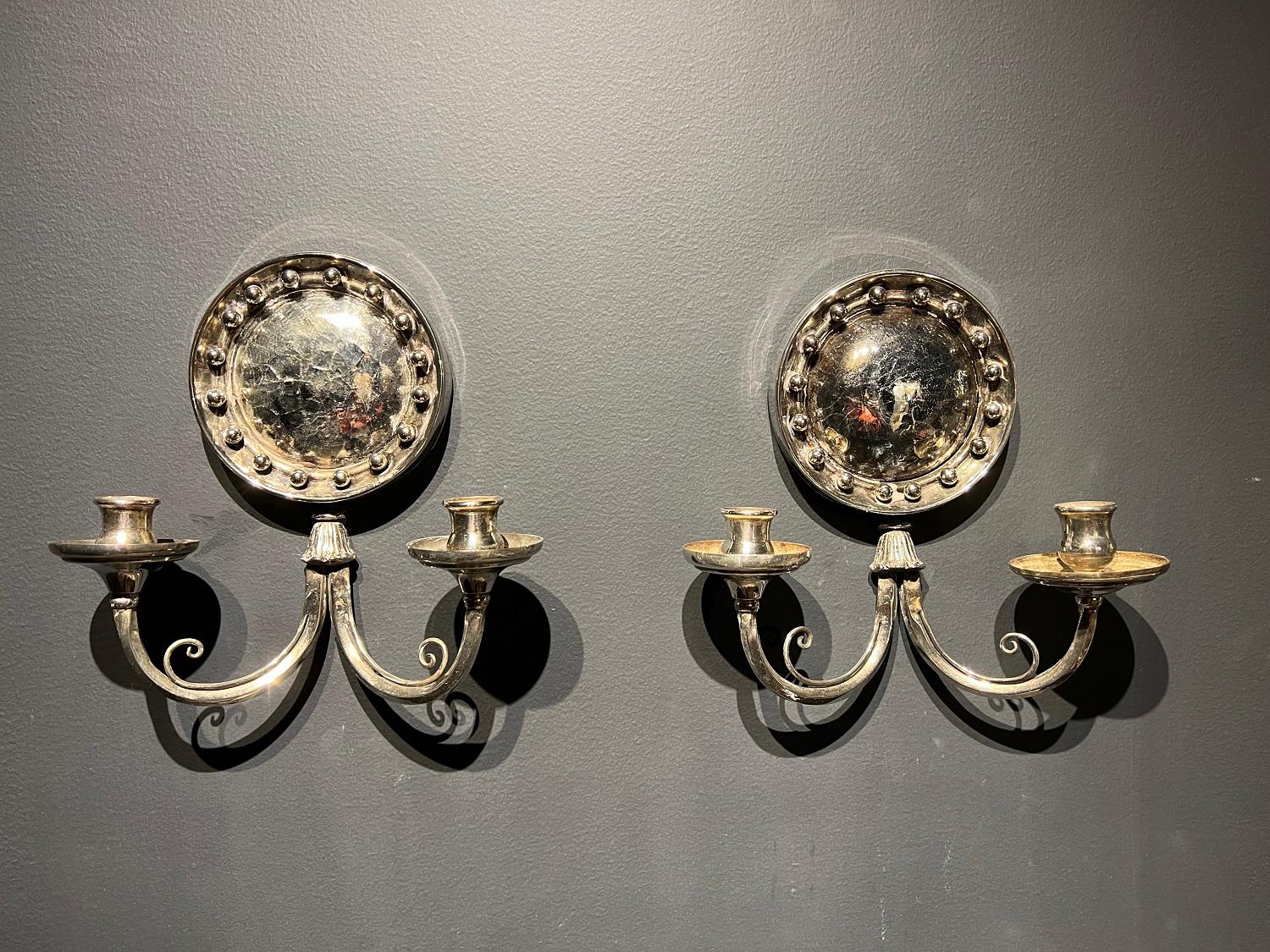 A pair of circa 1920’s Silver plated sconces with cracked mirrored backplate and two lights. Lamp shade is not included. In very good vintage condition. 

Up to 120V (US Standard)
Hardwired

Dealer: G302YP

