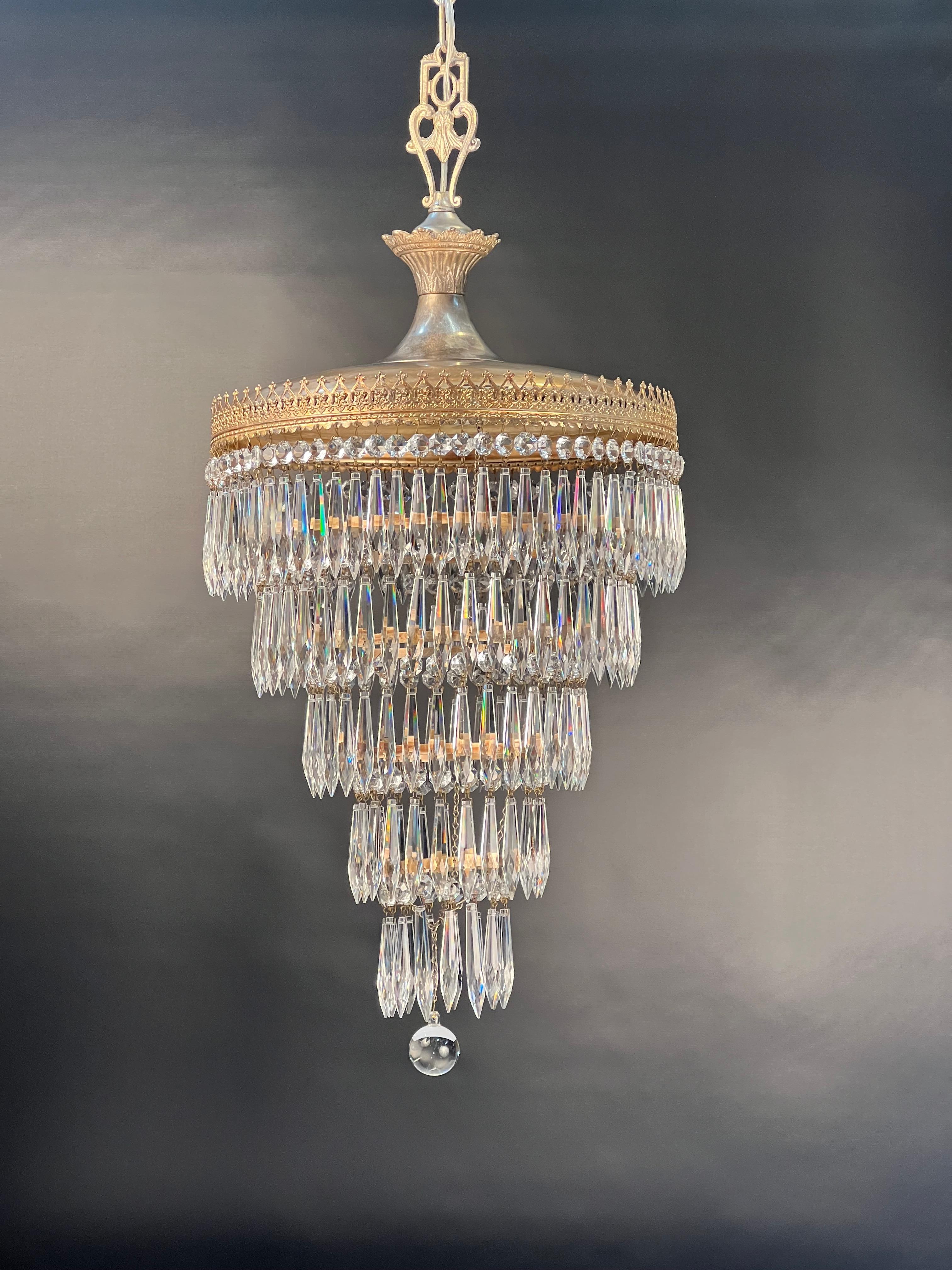 1920's silvered brass five tier wedding cake chandelier suspended from a silvered cast brass decorative loop.
