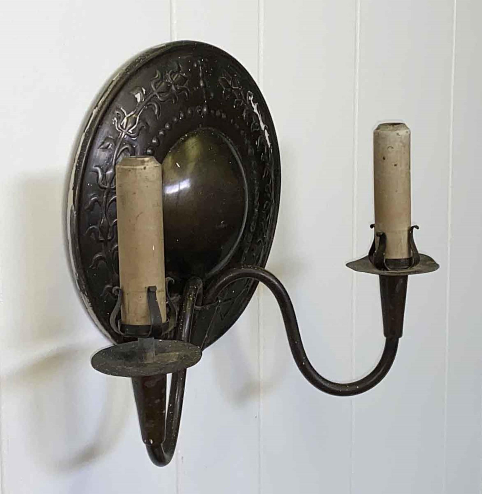 1920s Arts & Crafts hand-hammered brass wall sconce with dark finish. EF Caldwell signed with the original porcelain candle sticks. One available. This can be seen at our 400 Gilligan St location in Scranton, PA. 