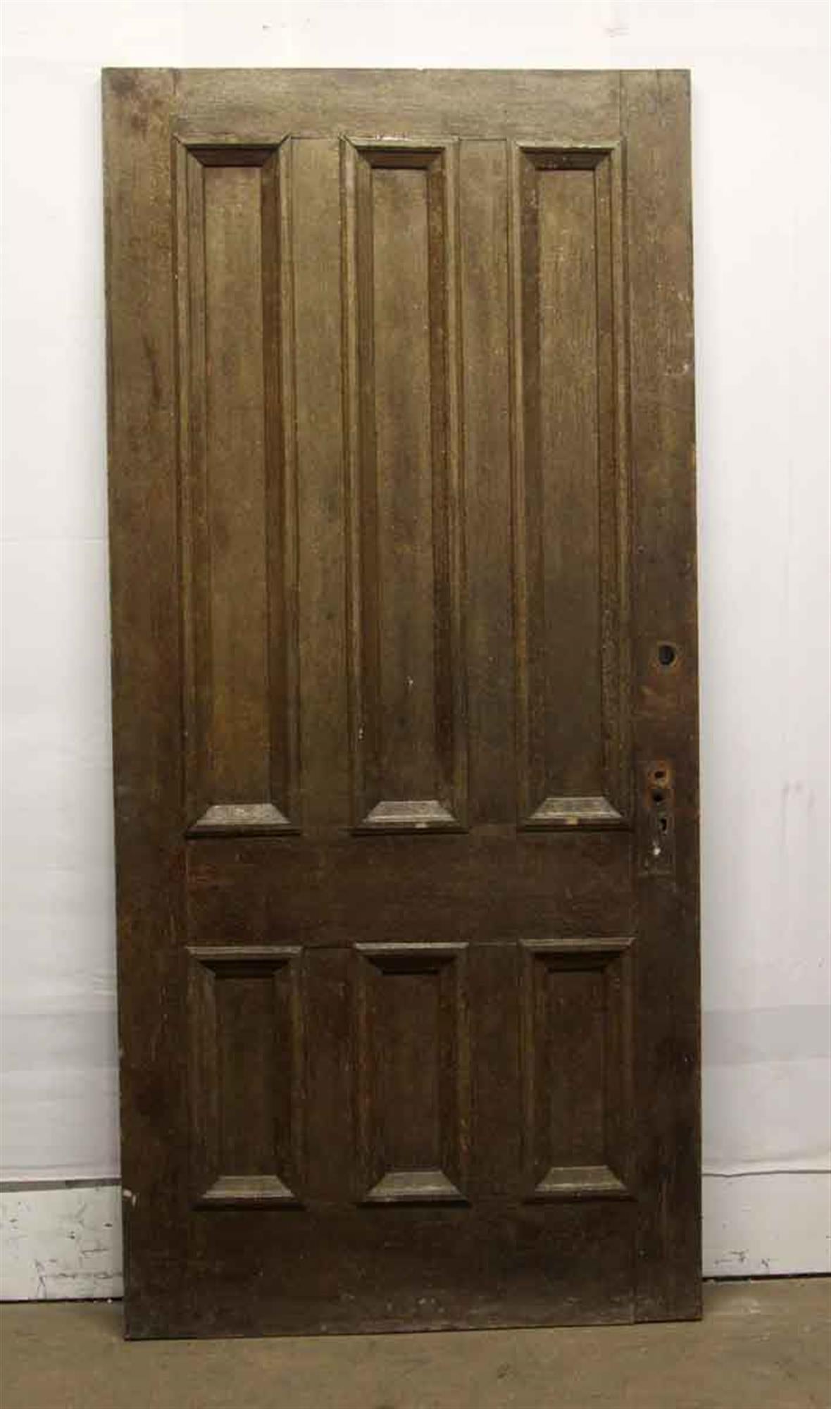 Unique dark wood tone privacy door made of chestnut with six vertical panels from the 1920s. This can be seen at our 400 Gilligan St location in Scranton, PA. 