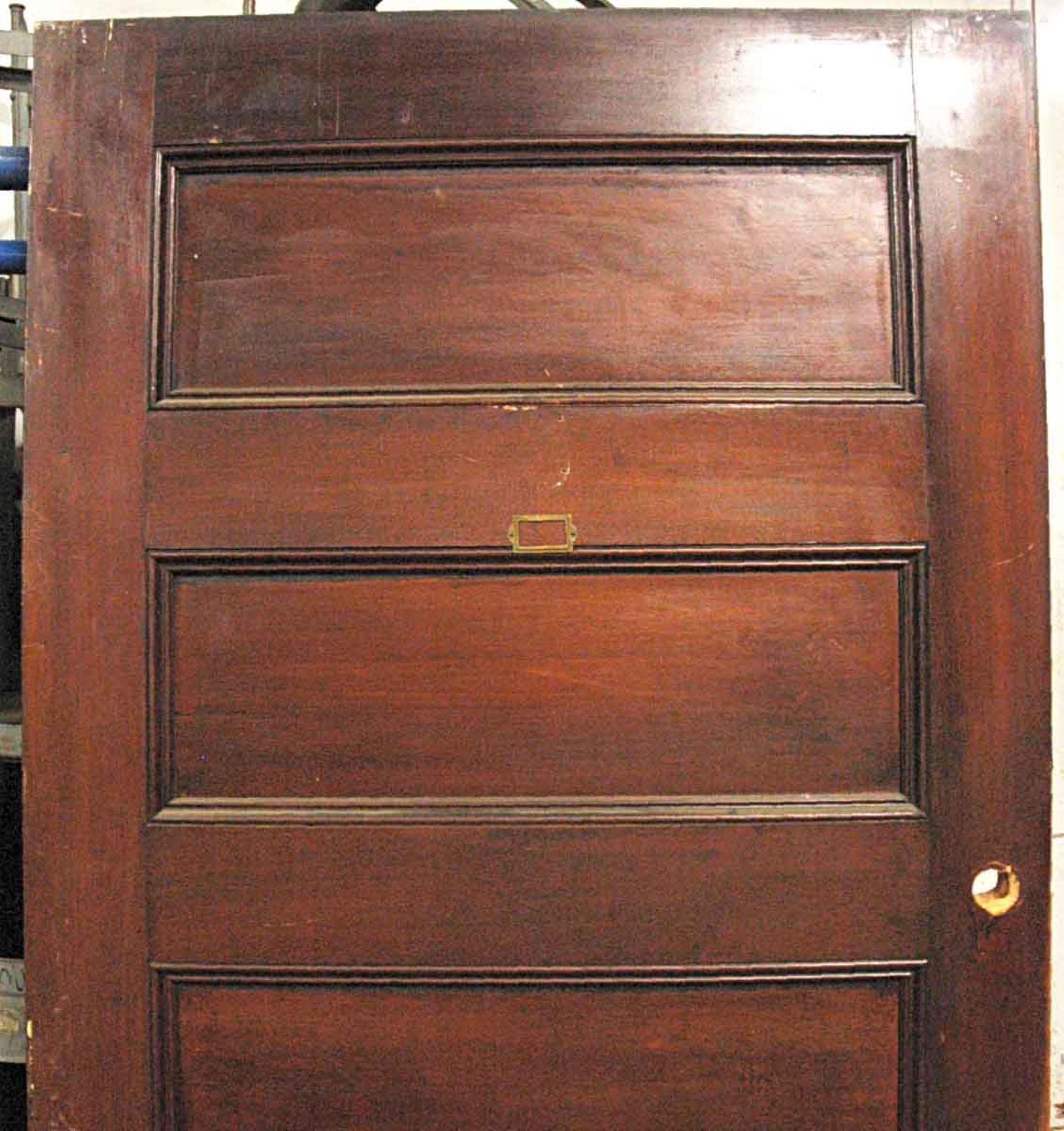 Solid core five panel door with a walnut veneer from the 1920s. Comes with attached escutcheons and a mortise lock. Minor scrapes and scratches. Once installed the door would swing inwardly towards the left. This can be seen at our 400 Gilligan St
