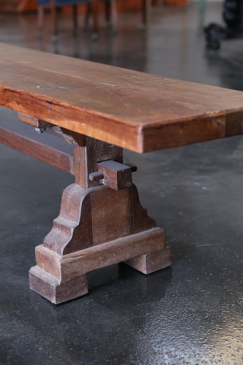 It is a flat bench with a solid thick top supported on two pedestals on either end. It is heavily built in the old world carpentry with immaculate butterfly joints. Benches like this one will last several generations. It stood the test of