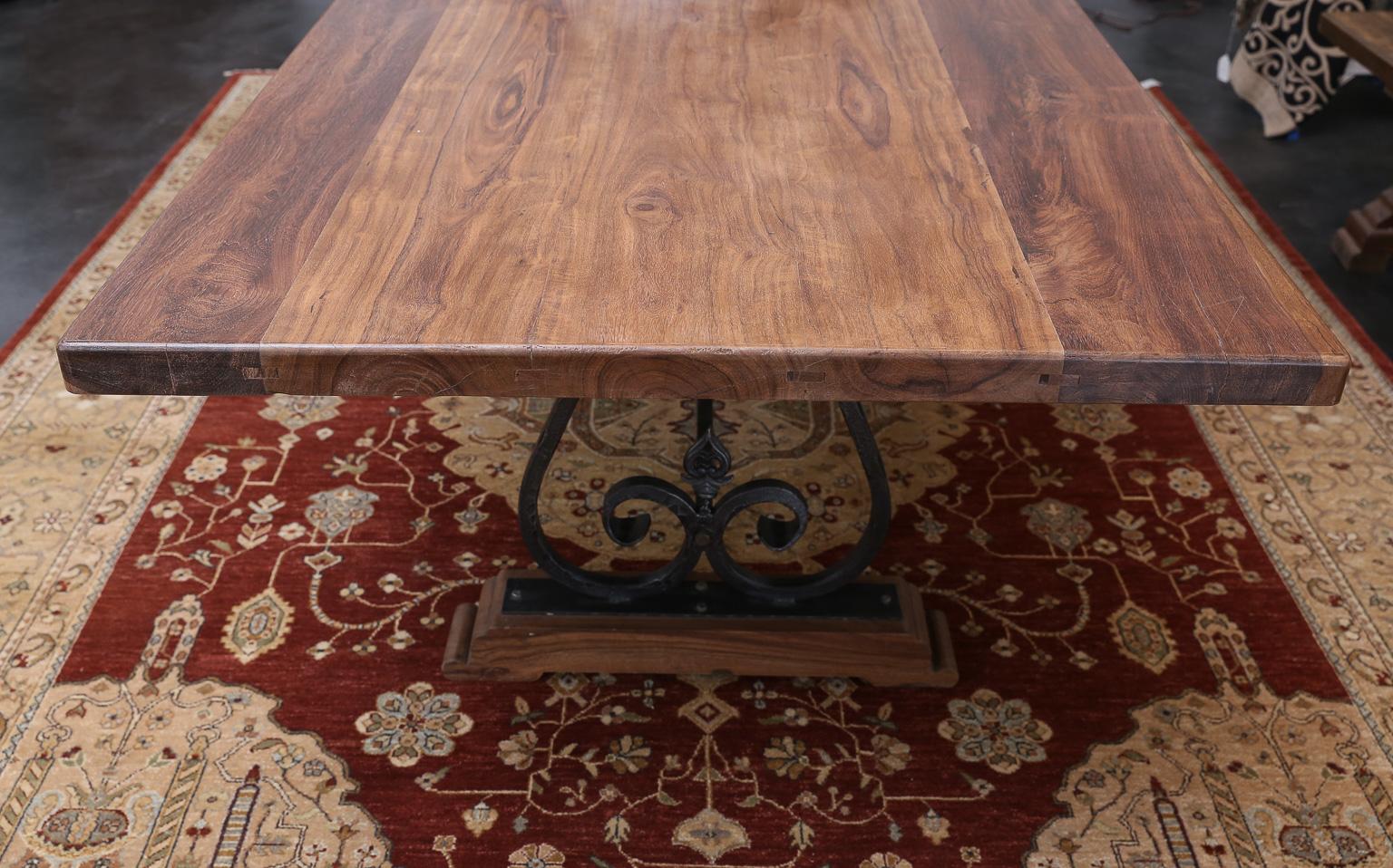 Thick fine solid teak wood top supported on two iron pedestals. Wood grain flow on the top is to be seen to know the quality of wood. Simple but elegant an extraordinary piece by any standard. The table is firm like a rock. Heavy hand forged wrought