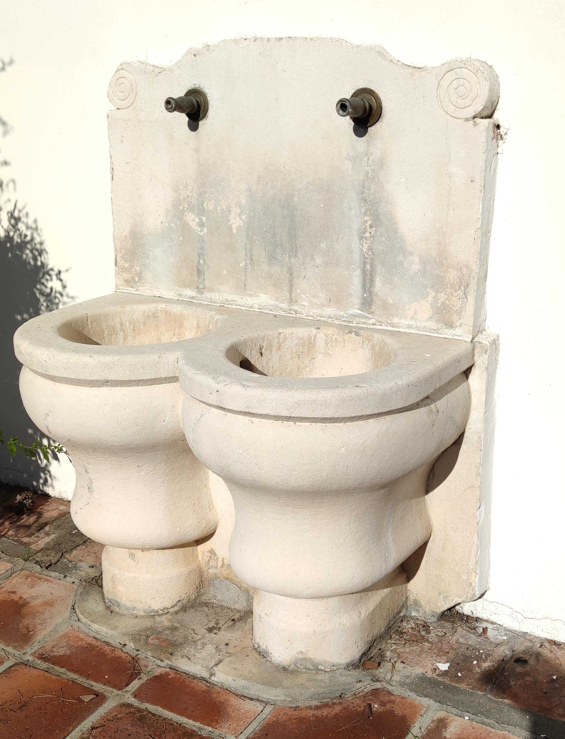 1920s Spanish hand carved limestone wall fountain with two spouts.