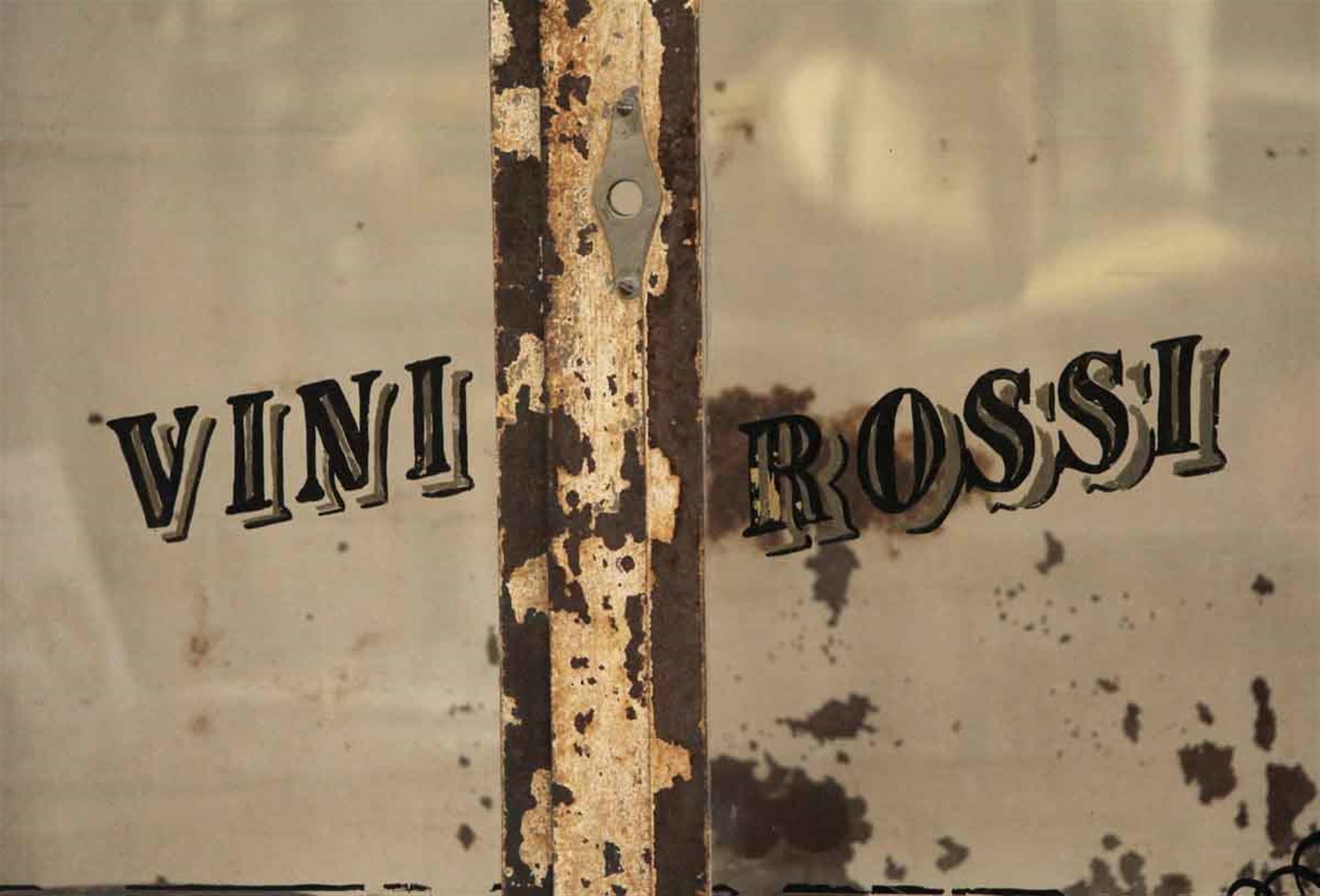 Distressed 1920s steel beverage cabinet made by N.S. Low & Co. Inc. The cabinet features a two glass door opening at the top, three middle drawers and a bottom opening. The glass is stamped Vini Rossi from its original owner. Refrigeration no longer