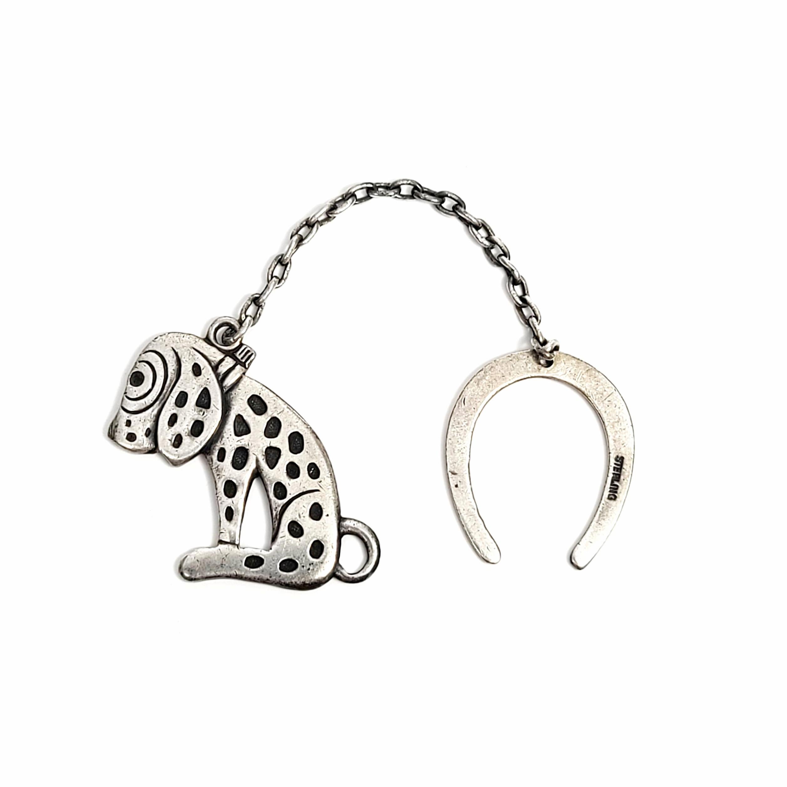 Vintage sterling silver Dismal Desmond charm and Horseshoe fob.

Dismal Desmond was a character created in the 1920s, his sadness over losing his owner became spots on his body. This charm is connected to a horseshoe fob by a short chain.

Desmond
