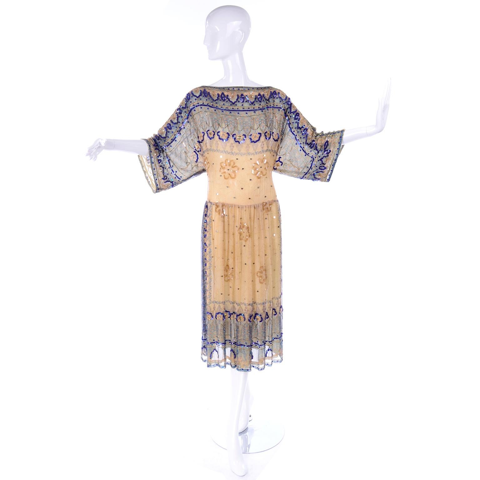 This is an exquisitely made Judith Ann Creations vintage dress made in the late 1970's or early 1980's in a 1920's style! The fabric is a beautiful tan and blue patterned fine silk, and the dress is covered in gold and blue sequins and beads. It is