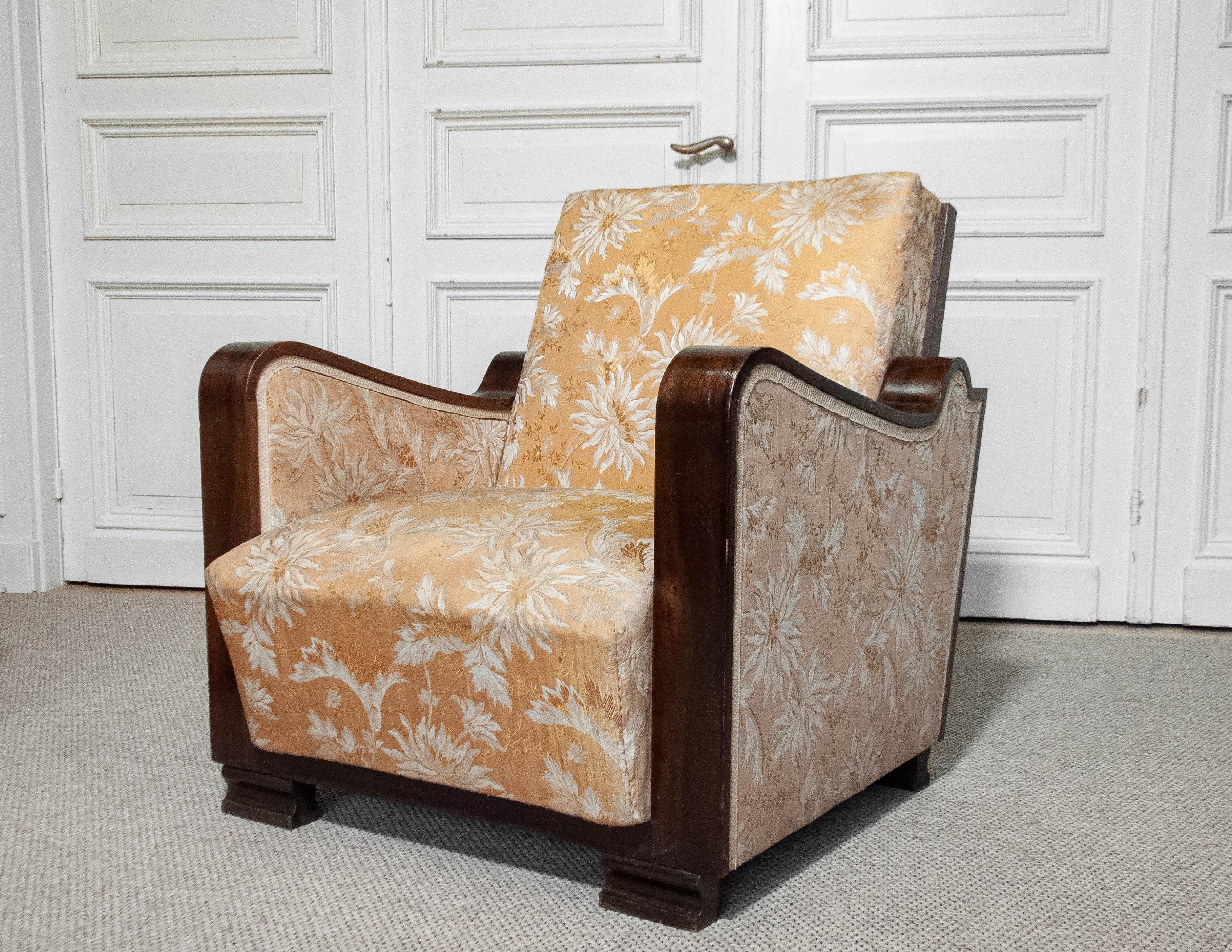 A stunning Swedish Art Deco armchair from the 1920s, featuring its original golden jacquard fabric with an elegant floral pattern. The fabric shows some wear consistent with age and use like little fading and little holes.The chair has a solid beech